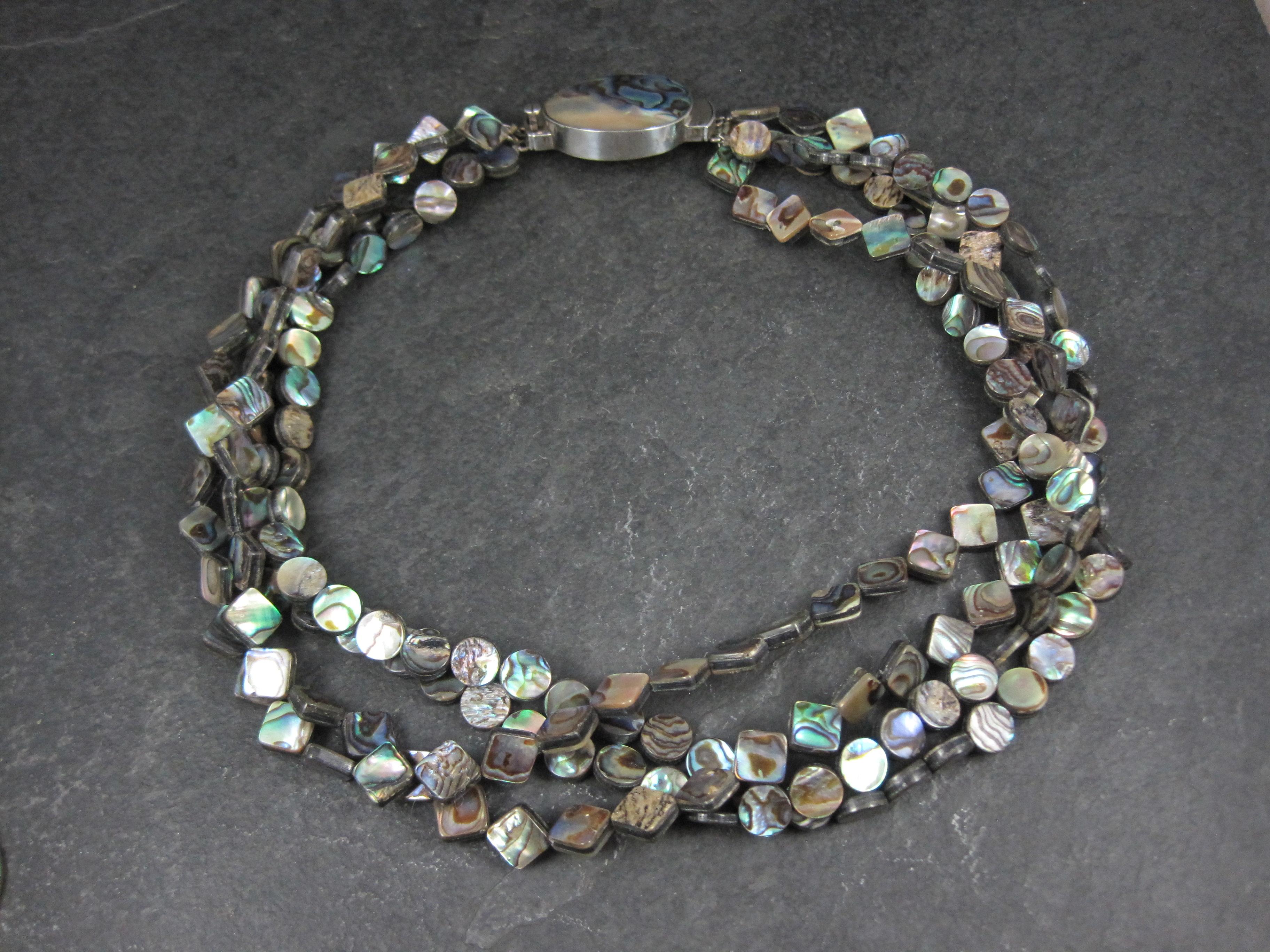 Questa splendida collana di proprietà presenta 4 fili di abalone e una splendida chiusura in abalone e argento sterling.
La collana misura 17 pollici indossabili.
La chiusura misura 7/8 per 1 1/2 pollici. 
Questa collana può essere indossata con la