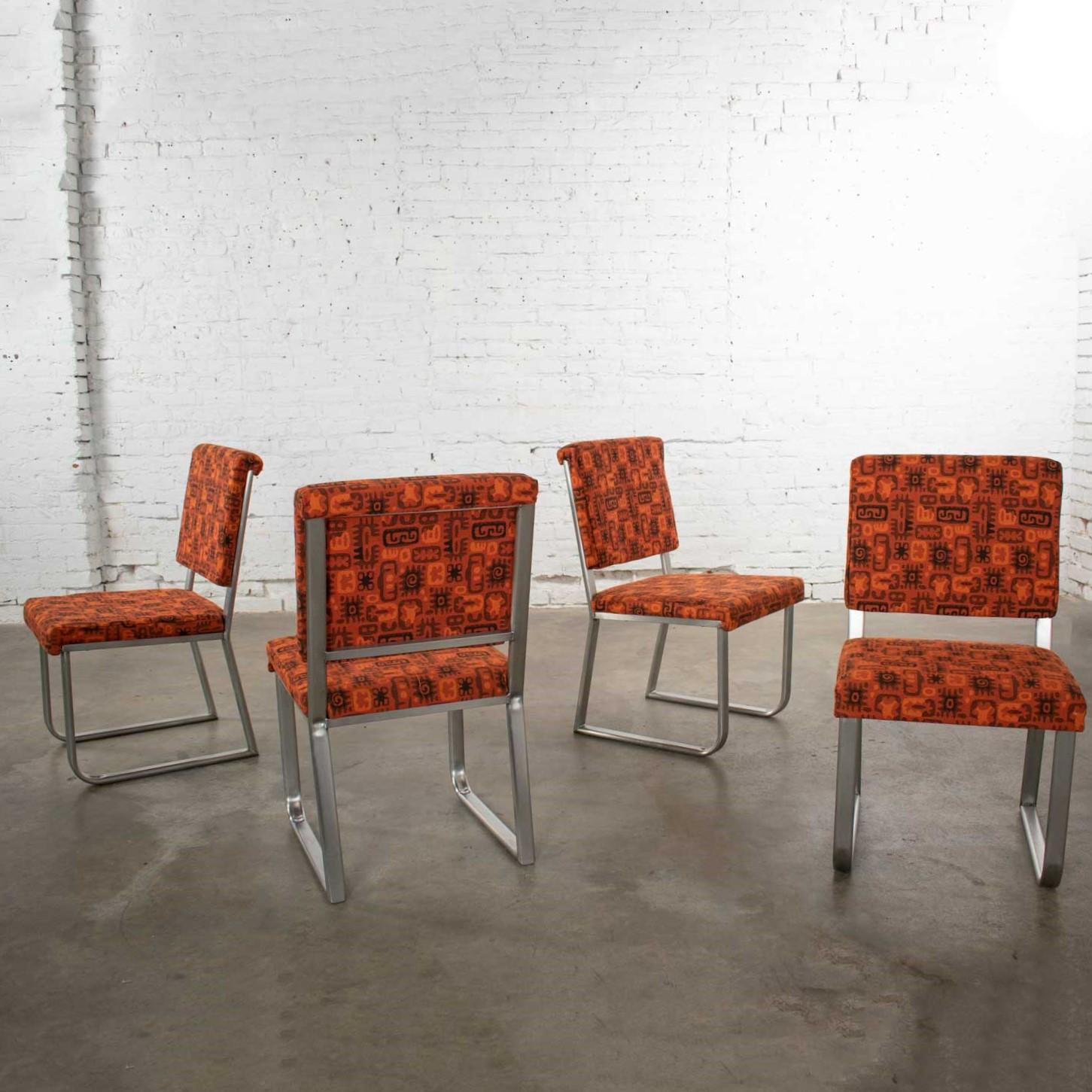 Outstanding set of four Streamline Modern, Mid-Century Modern, Art Deco, or Industrial modern railroad dining car chairs in stainless steel with original orange abstract upholstery. They are in fabulous original condition and ready to use. Please