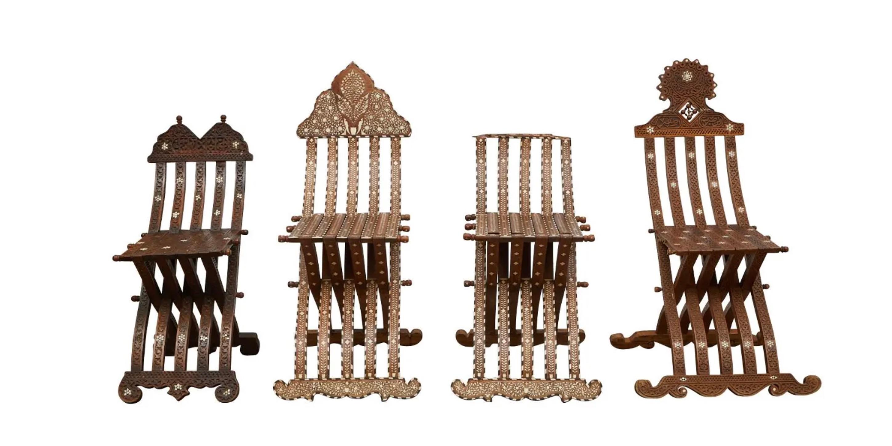 Group of four Syrian mother of pearl inlaid wooden folding scribe chairs including one matching pair. The carved wood is inlaid with intricate geometric and floral designs of mother of pearl with the intarsia method.

Provenance: From the Estate