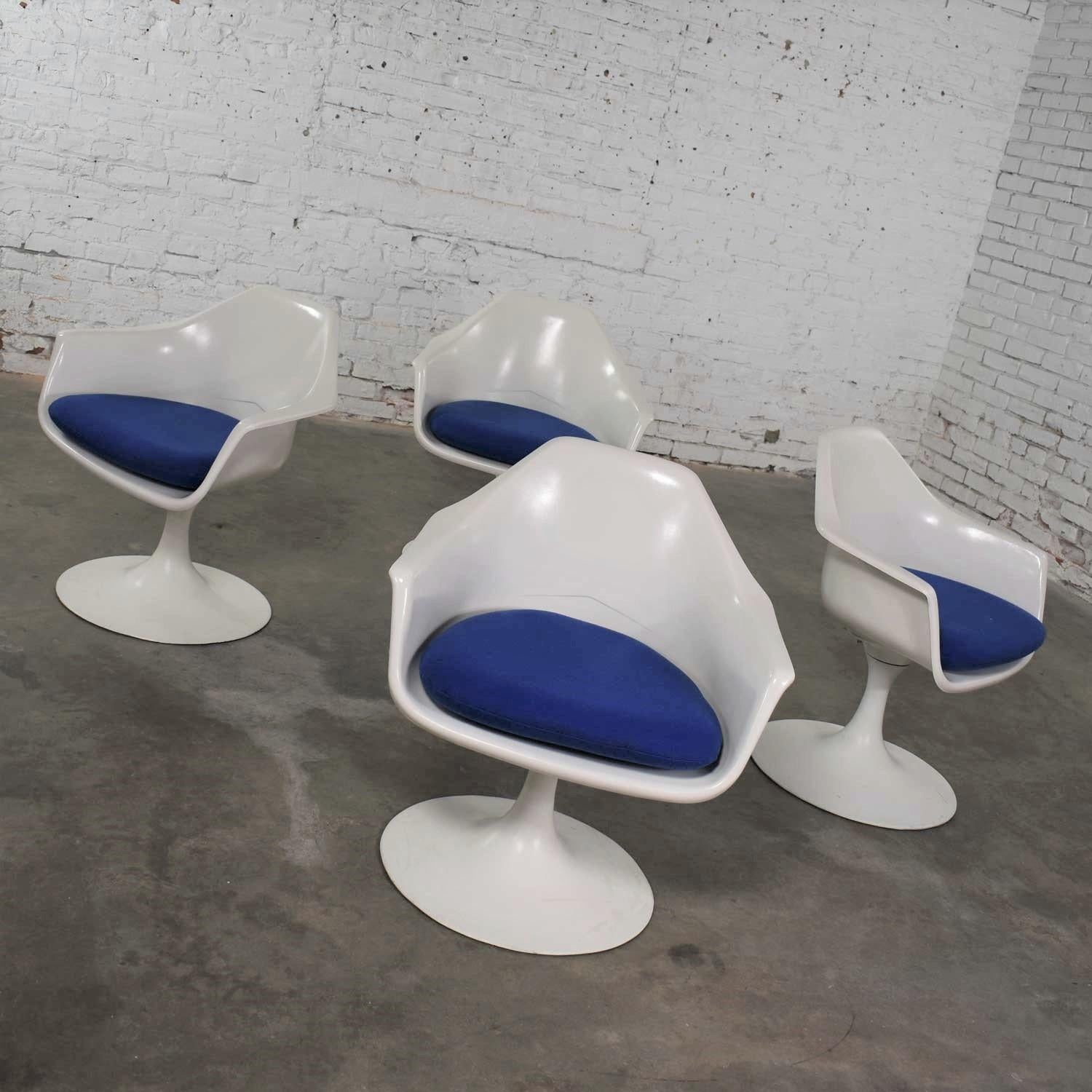 Handsome set of four tulip style white fiberglass swivel armchairs with royal blue seat cushions designed by Arthur Umanoff for Contemporary Shells. These are era appropriate vintage chairs done in the style of Eero Saarinen for Knoll. They are in