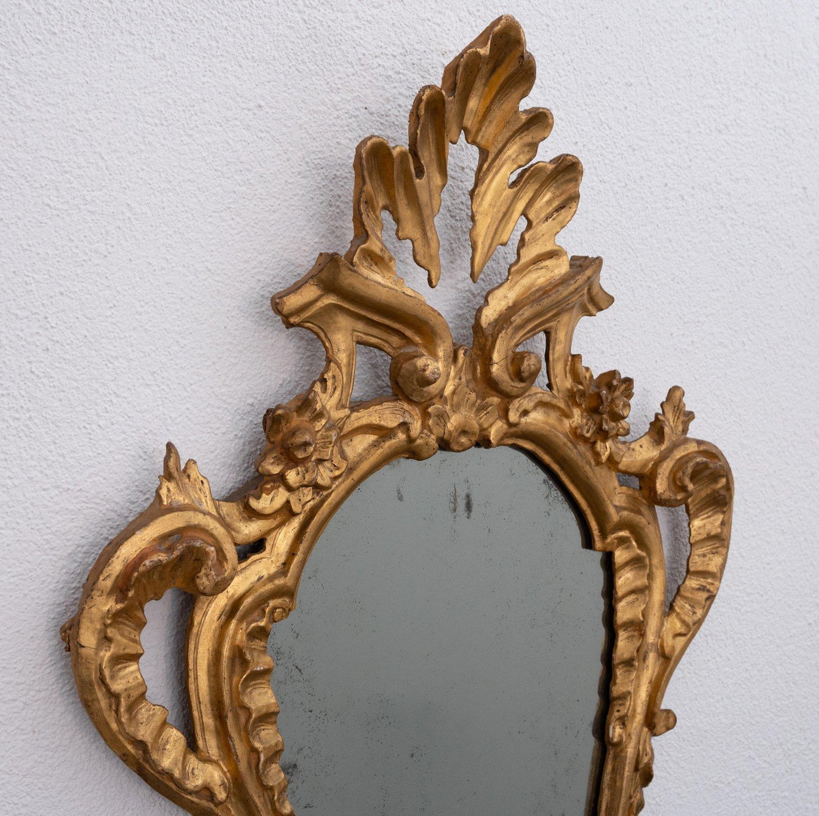 Set of four Italian carved giltwood girandoles, probably Tuscan, Italy circa 1800 priced for the four. Several repairs, oxidation to the mirror plates, sconces lacking.