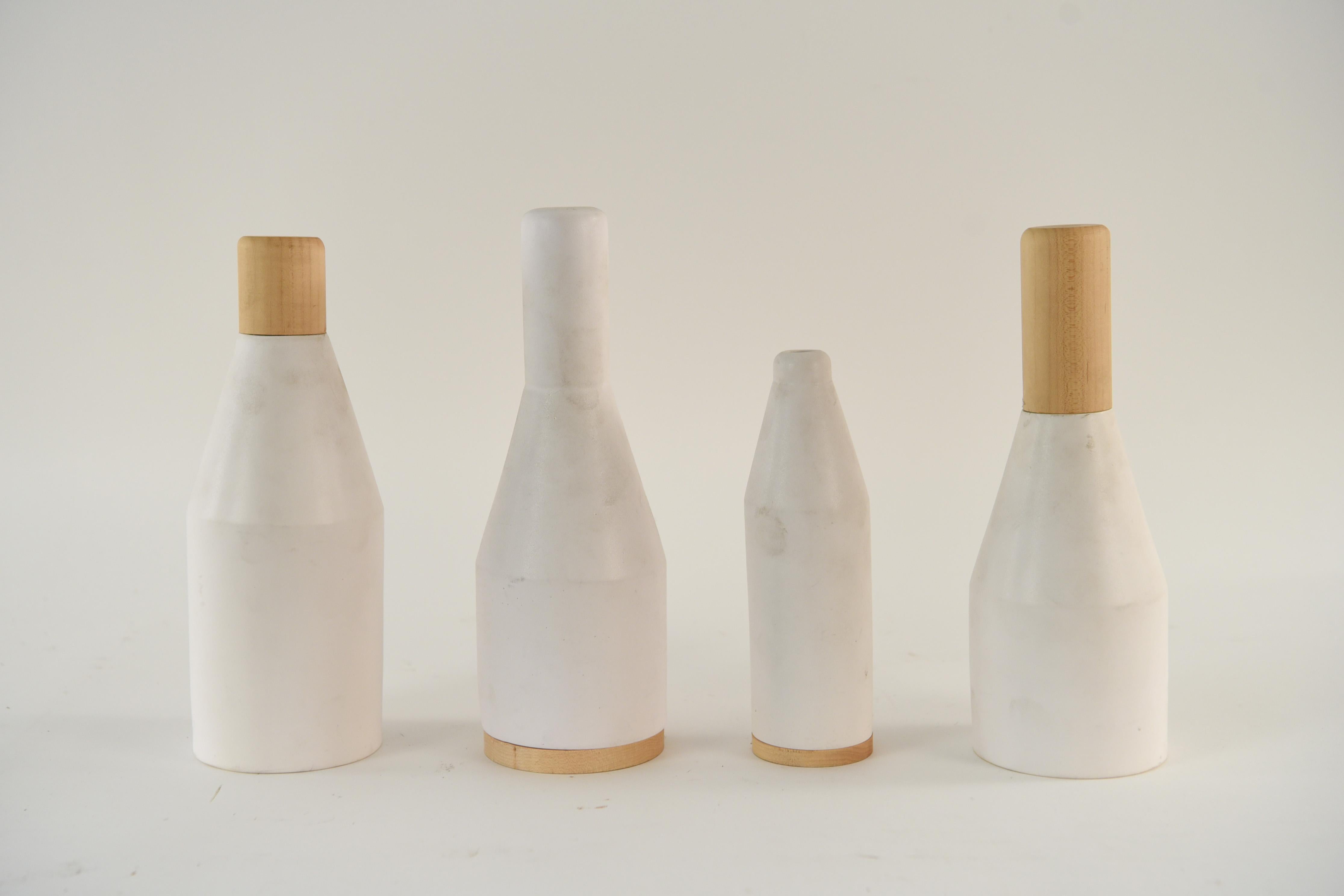 This set of four ceramic decorative items has a clean modern look. Two have holes and can function as vases. Two are closed and for decorative purposes only. Forms and vases mixed with wood. The Forms No Figures collection was inspired by industrial