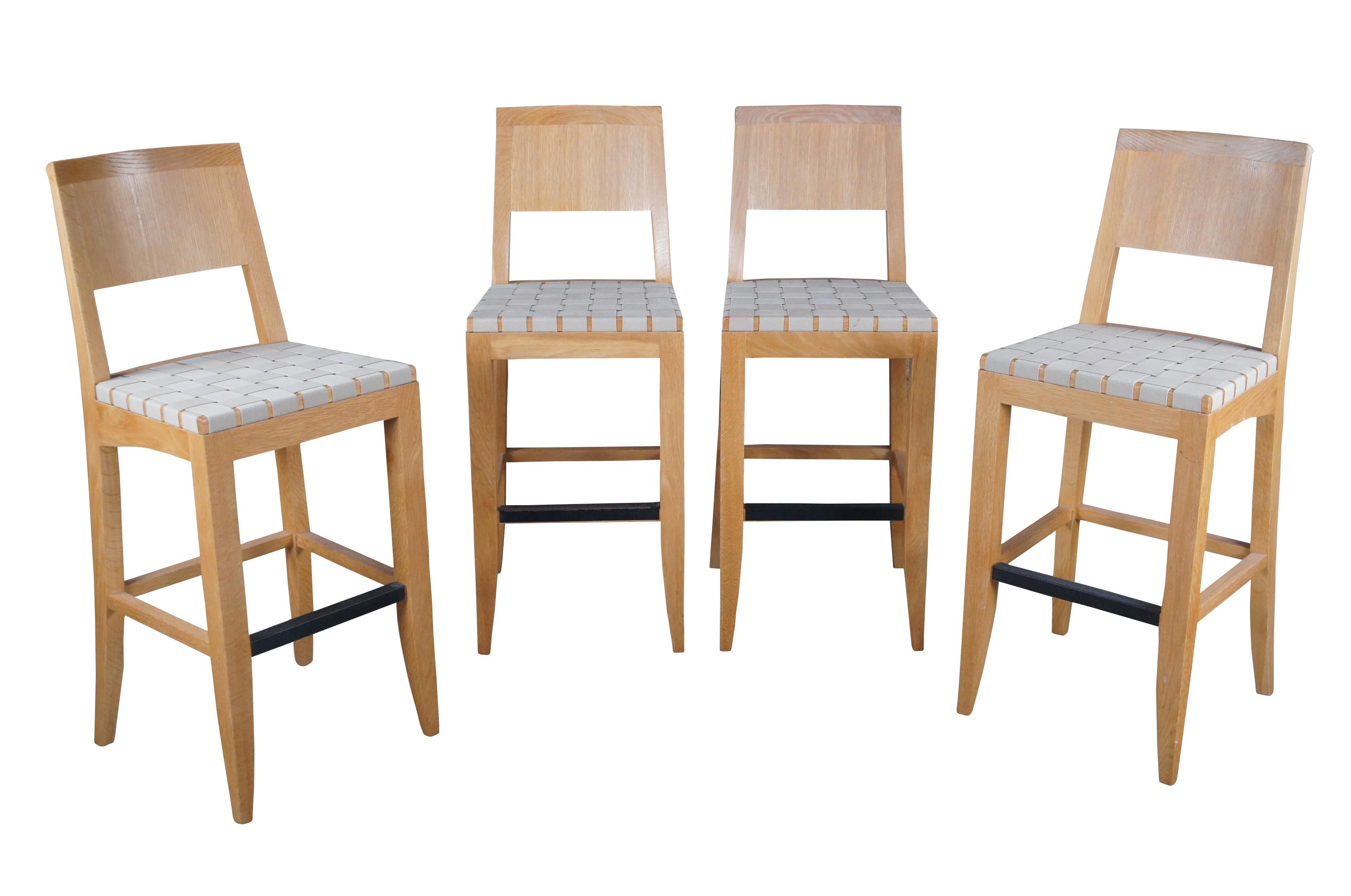 A sturdy set of solid oak bar stools with woven strap seats. Features a foot rest with metal cover and triangular cut crest rail.