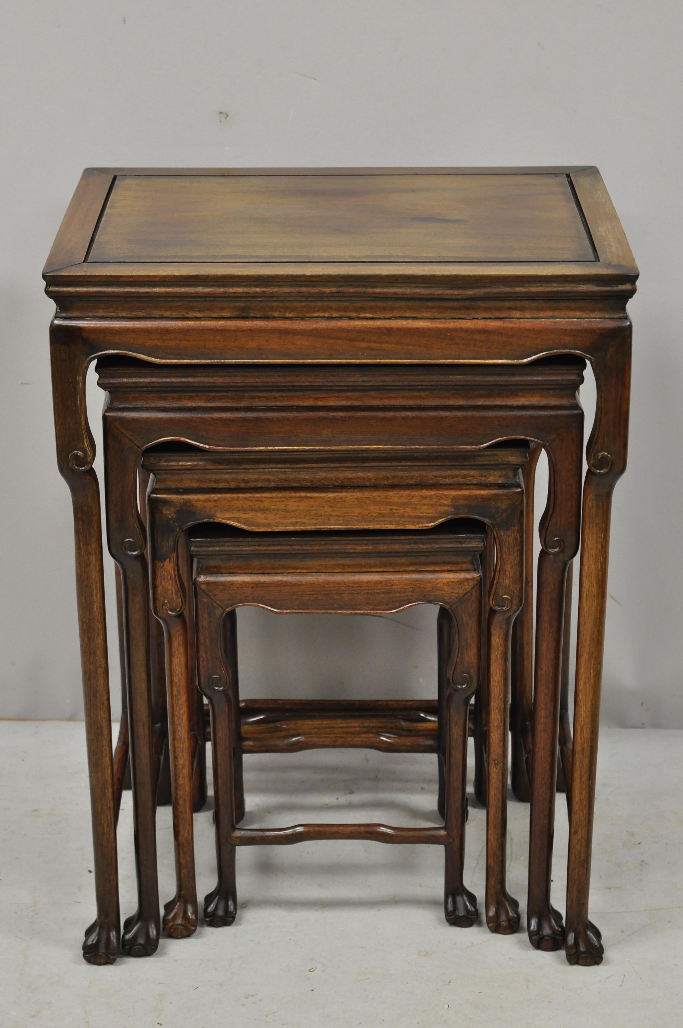 4 vintage Chinese carved hardwood rosewood nesting side tables with paw feet. Listing includes a solid wood construction, beautiful wood grain, nicely carved details, quality American craftsmanship, great style and form, circa mid-20th century.