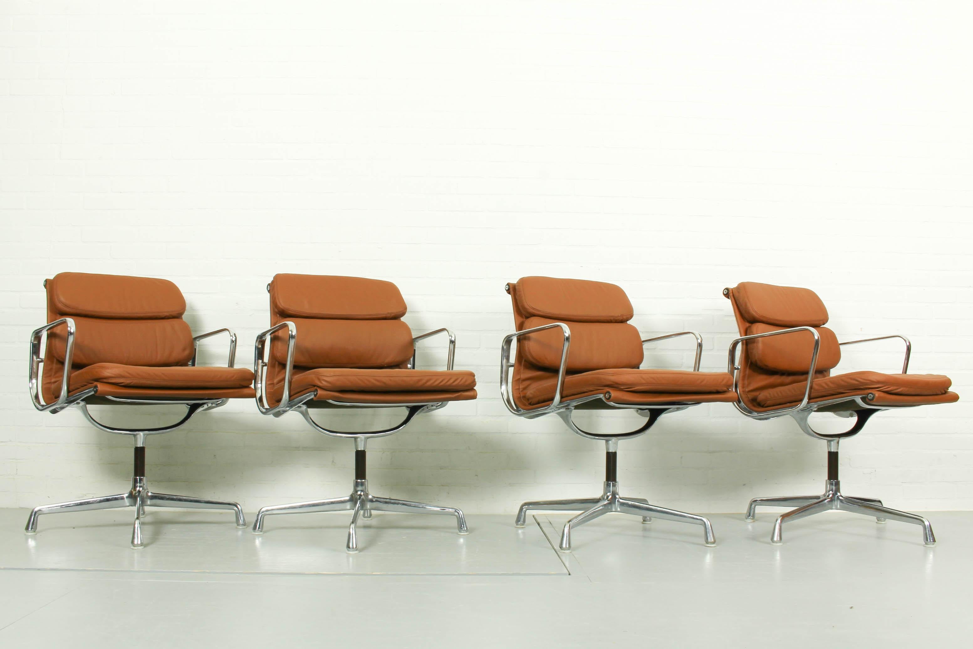 Set of 4 vintage cognac leather aluminum chairs designed by Charles and Ray Eames and manufactured by Vitra. In cognac leather.