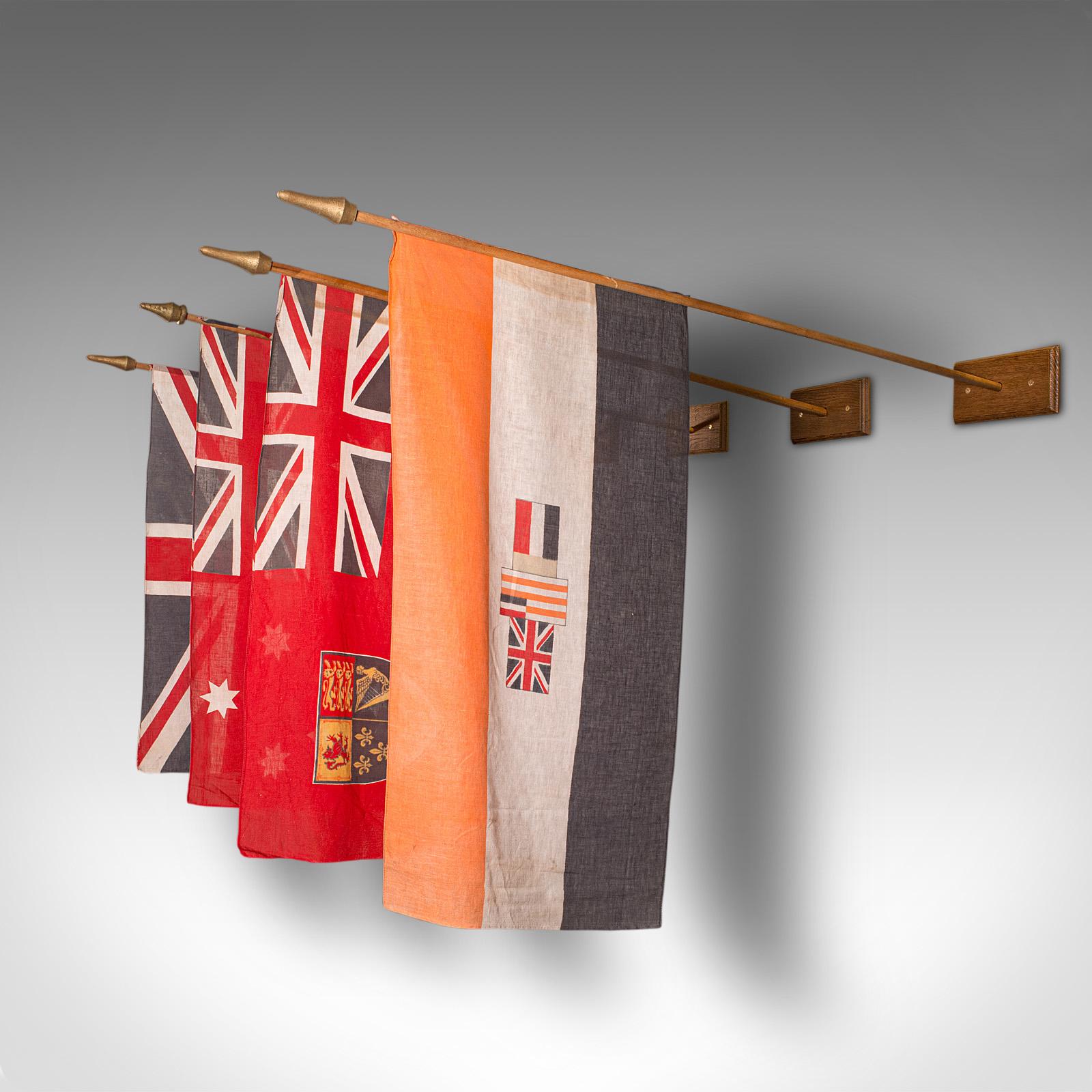 This is a set of 4 vintage Empirical embassy flags. A Commonwealth, cotton official flag upon an oak mount, dating to the mid 20th century and later.

Comprising the classic United Kingdom Union Jack, the Australian red ensign for Merchant Navy