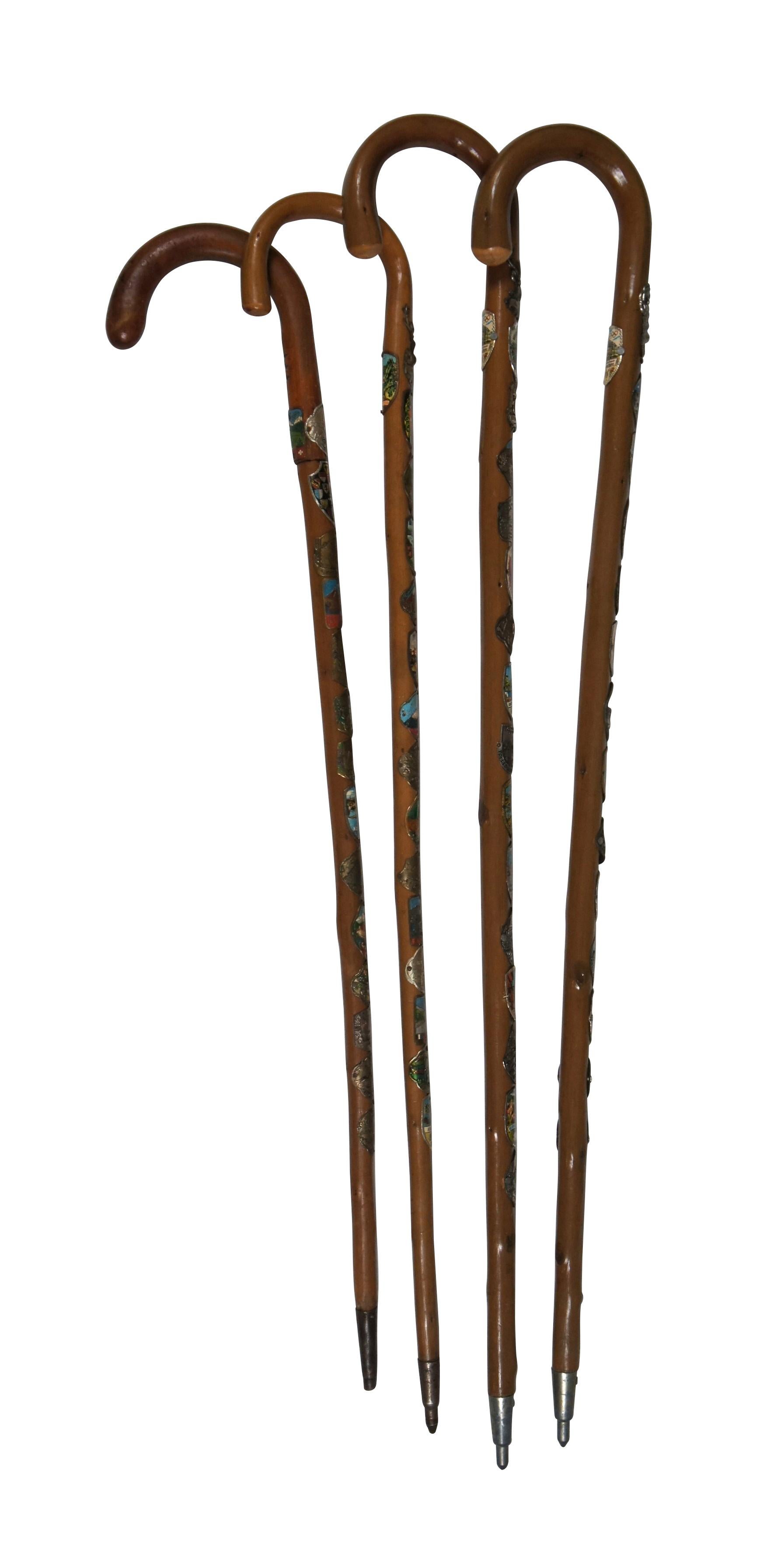 Lot of four vintage German / Austrian folk art traditional hook style walking sticks / canes, embellished with German and other assorted European hiking souvenir badges. 63 total badges across the four canes with several repeats. Olympics, Munchen,