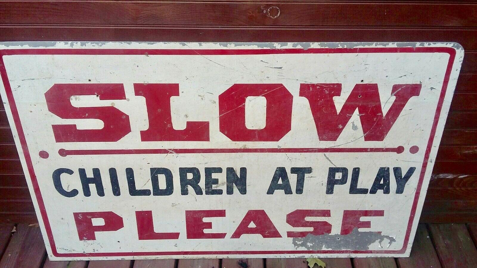 Vintage metal sign letting people know to slow down for the children playing in the street. Great coloring and graphics. Red and black lettering on white background. 4 feet wide by 3 feet tall.
