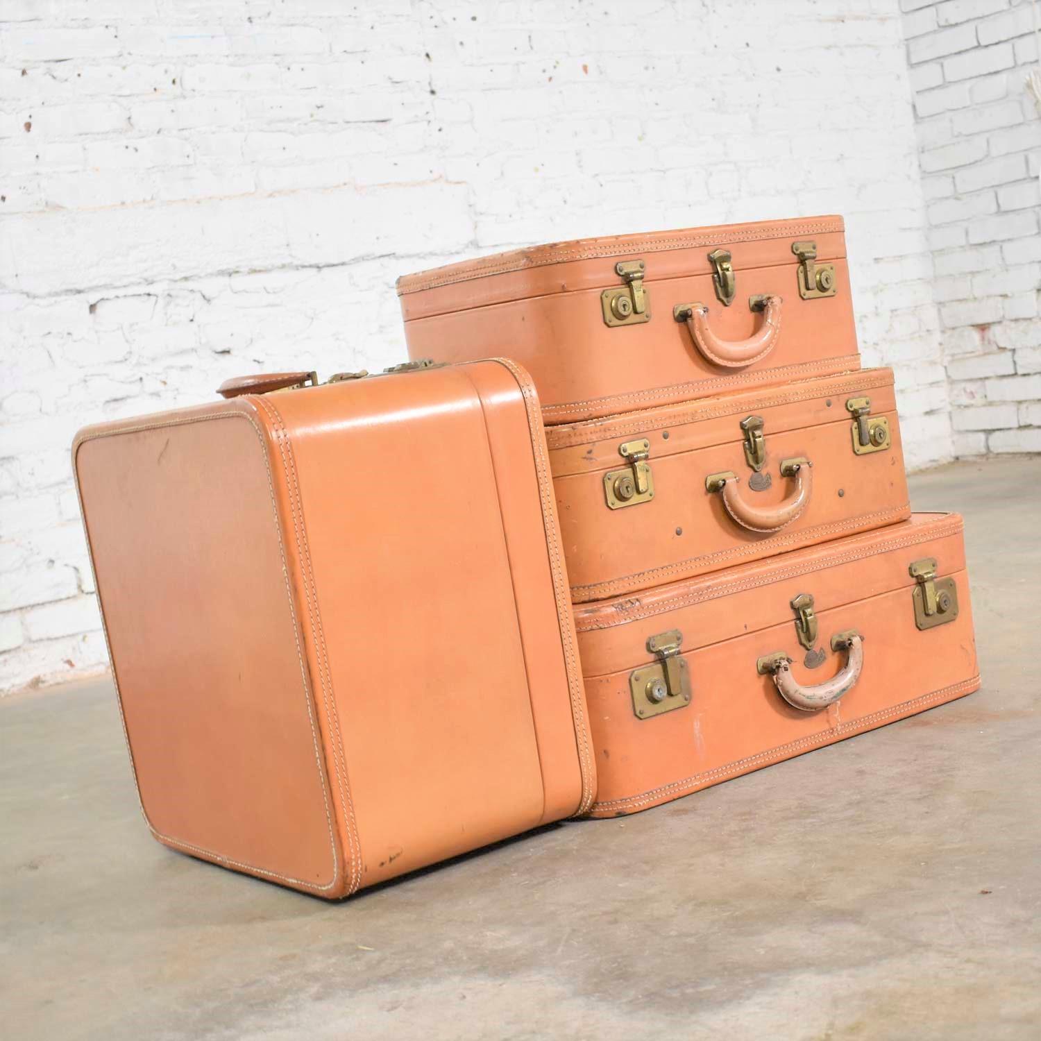 Handsome set of four (4) vintage leather suitcases by Stratosphere Rappaport Chicago. We have stacked them as side tables or end tables. They are in overall wonderful vintage condition. They do have lots of beautiful patina including scratches,
