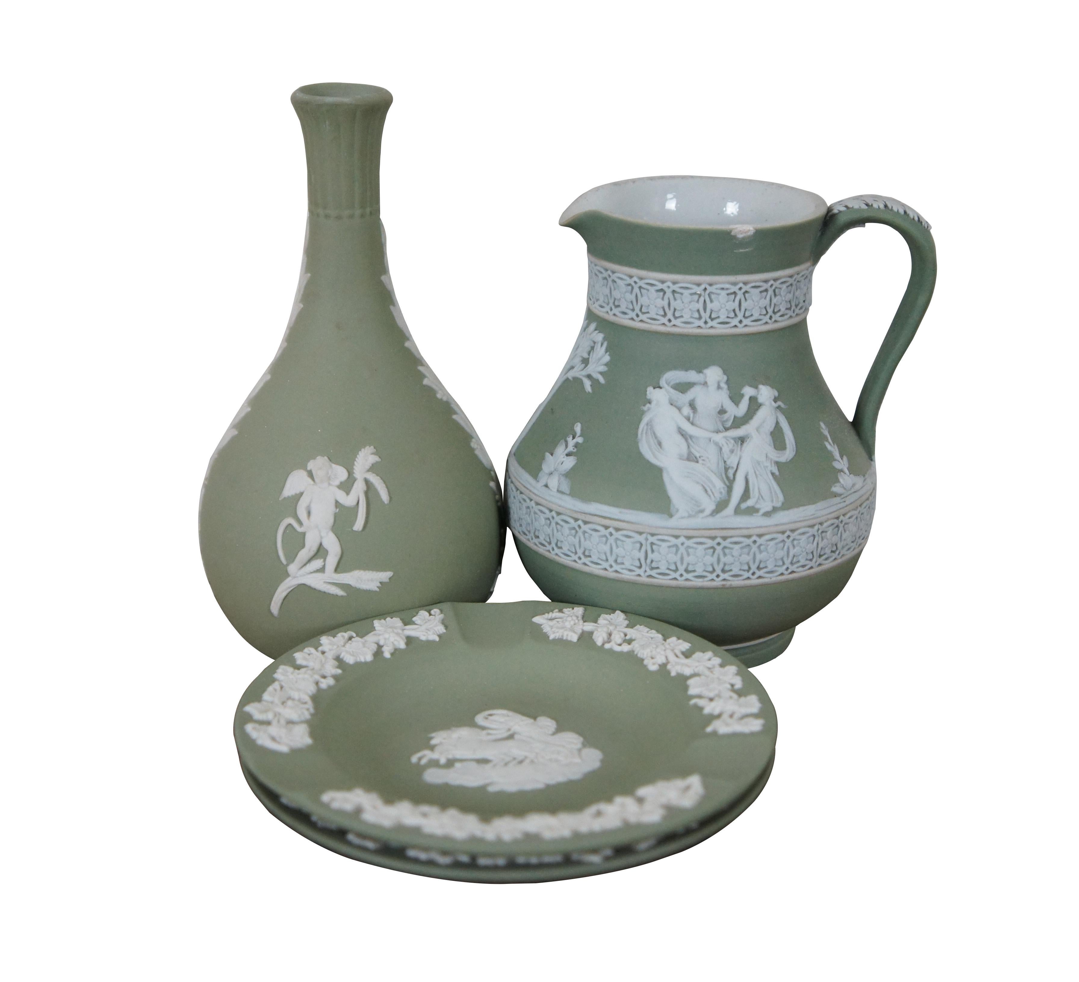 Lot of four pieces of wedgwood cream on sage green Jasperware, including a bud vase, small pitcher, round dish, and individual ashtray.

Measures : Pitcher - 4.25” x 4” x 4.5” / Bud Vase - 3” x 5.5” / Round Dishes - 4.5” x 0.5” (Width x Depth x