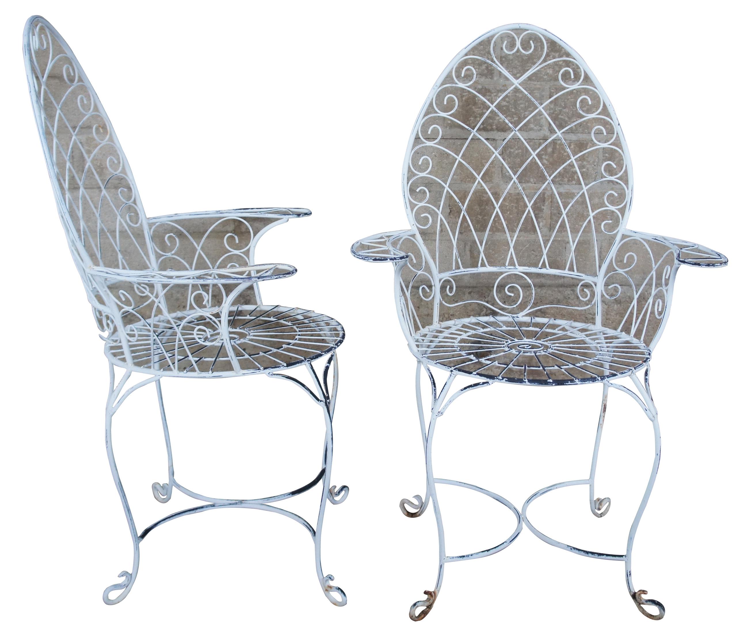 Set of four vintage wrought iron patio or parlor chairs. Features scrolled and spiral accents, arched back and nice patina.
 