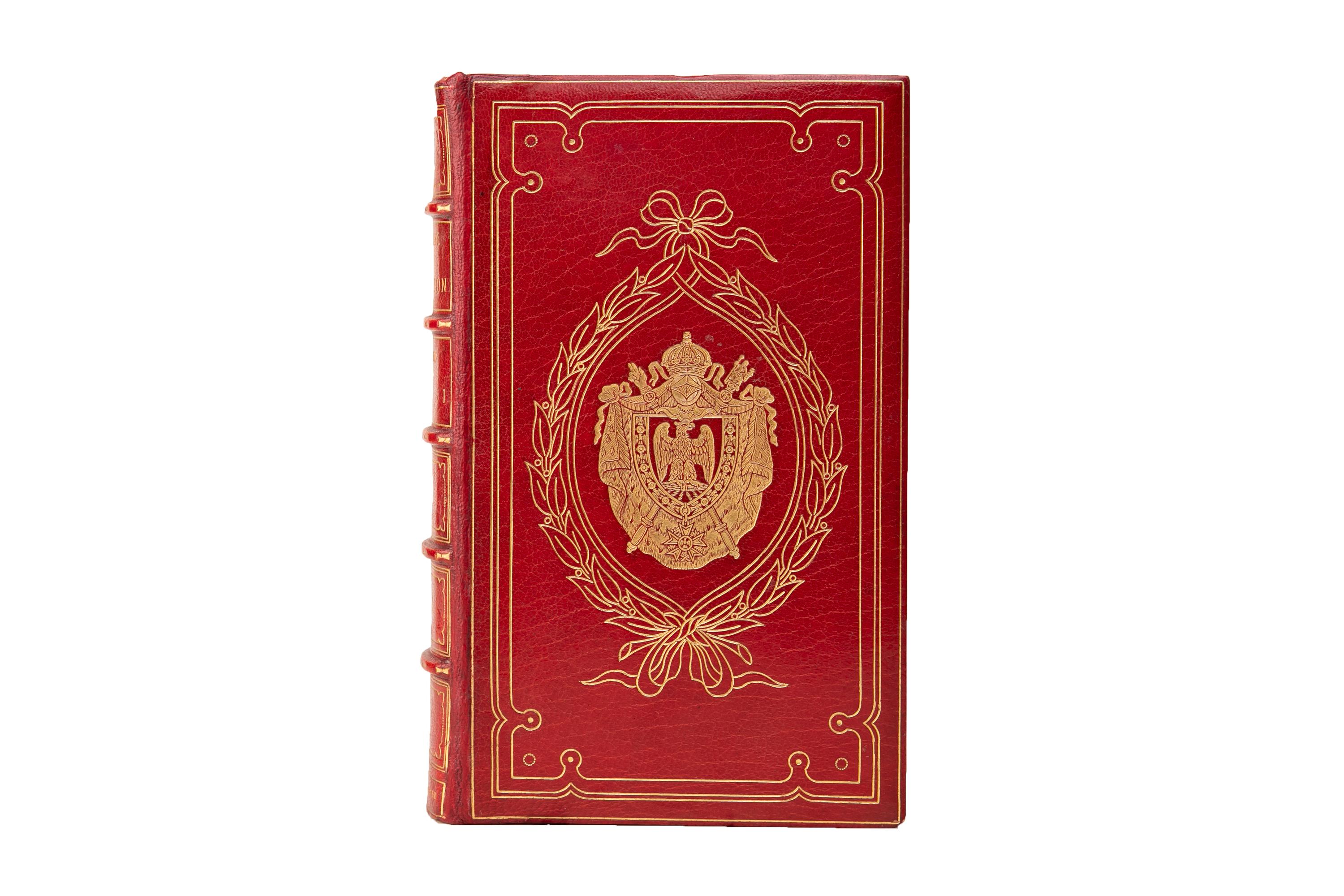 4 Volumes. W.H. Ireland, Life of Napoleon Bonaparte. Bound by Bayntun in full red morocco with the covers and raised band spines decorated in ornate gilt-tooling. All of the edges are gilt with ornate cosway-style portraits behind glass, black and