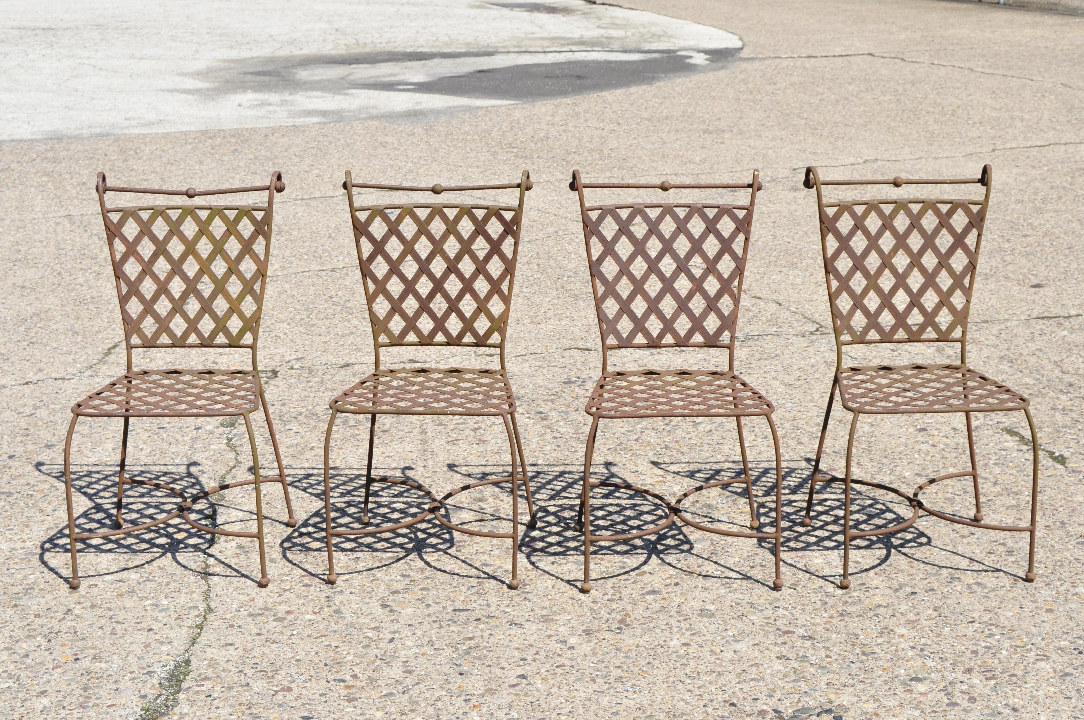 4 vintage woven lattice wrought iron Italian neoclassical garden patio dining chairs. Listing features lattice design backs and seats, shapely rolled backs, stretcher base, ball form feet, wrought iron construction, distressed finish, quality