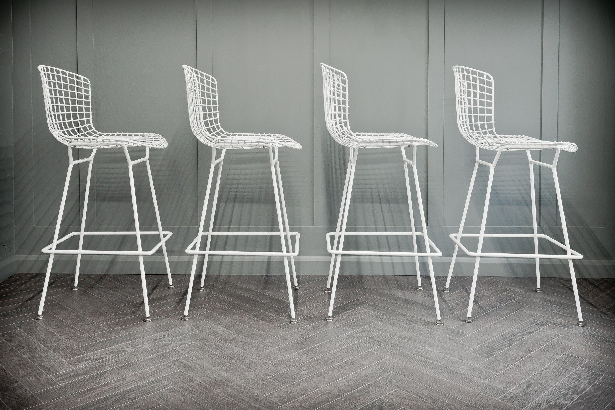 Harry Bertoia's 1952 experiment was bending metal rods into art pieces and just so happened to produced a admired collection of seating, one of which was this wire style barstool. Four stools complete this particular set all finished in white set on