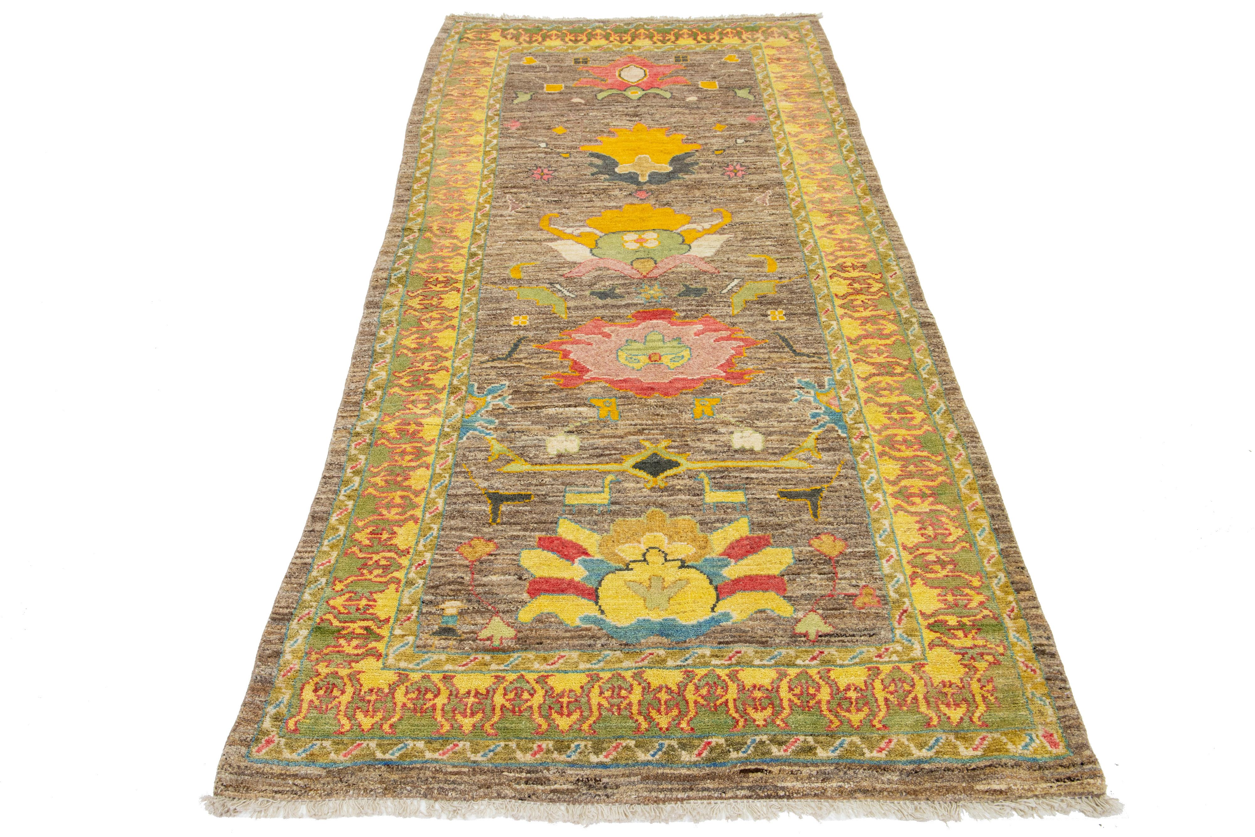 This hand-knotted wool rug features a lovely brown base and a stunning floral pattern with vibrant yellow, gray, red, and green accents. It's an exquisite addition to any decor.

This rug measures 4'3