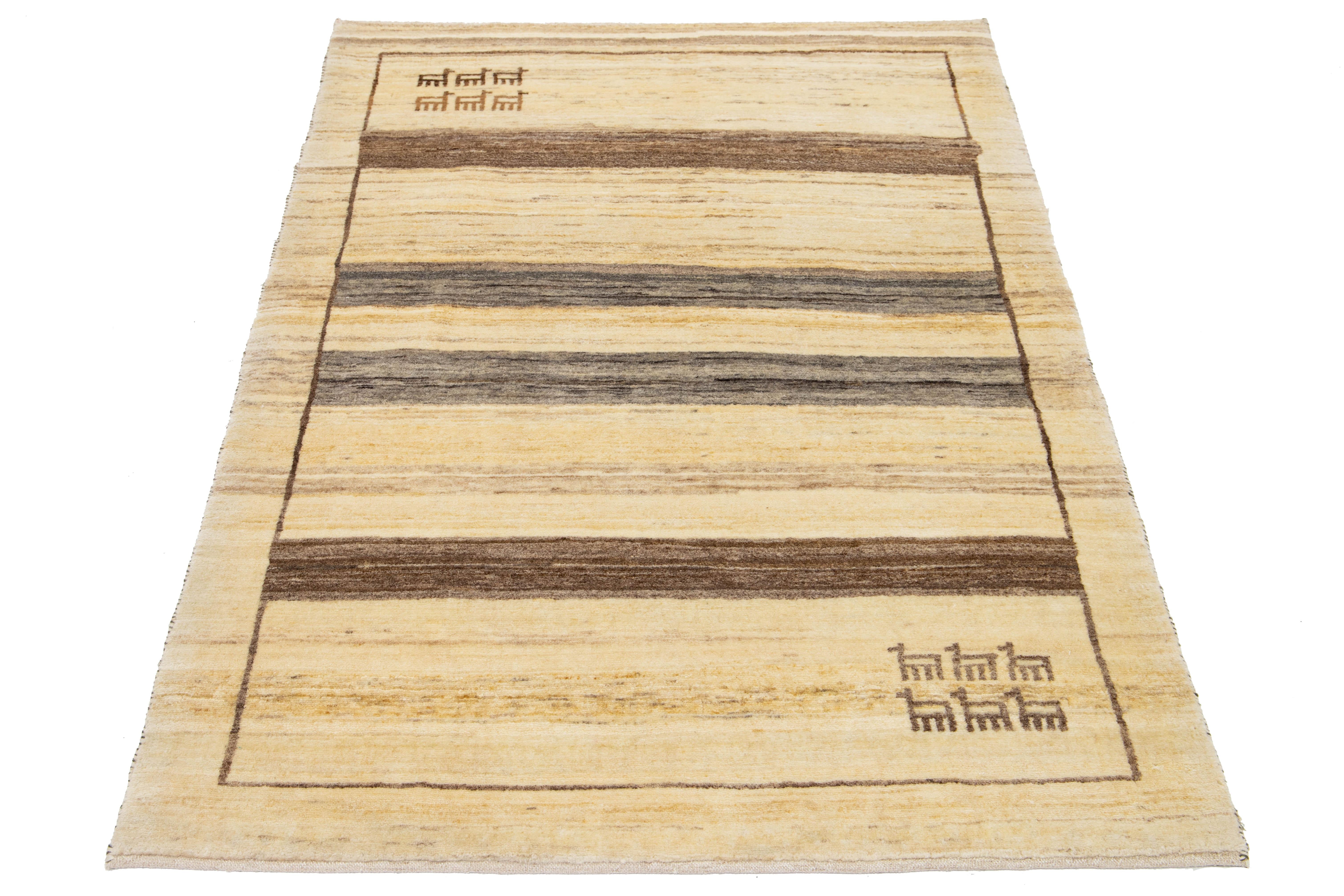 This contemporary Gabbeh rug is expertly hand-knotted, featuring a stylish striped design. Its soft beige base is beautifully complemented by gray and brown accents, adding a touch of sophistication to any space.

This rug measures 3'8'' x 5'2''.


