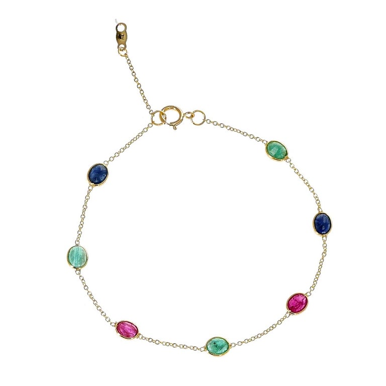 A 4 x 5MM Oval Ruby, Blue Sapphire and Emerald 18k Yellow Gold Adjustable Bracelet. The length of the bracelet is 7.50.