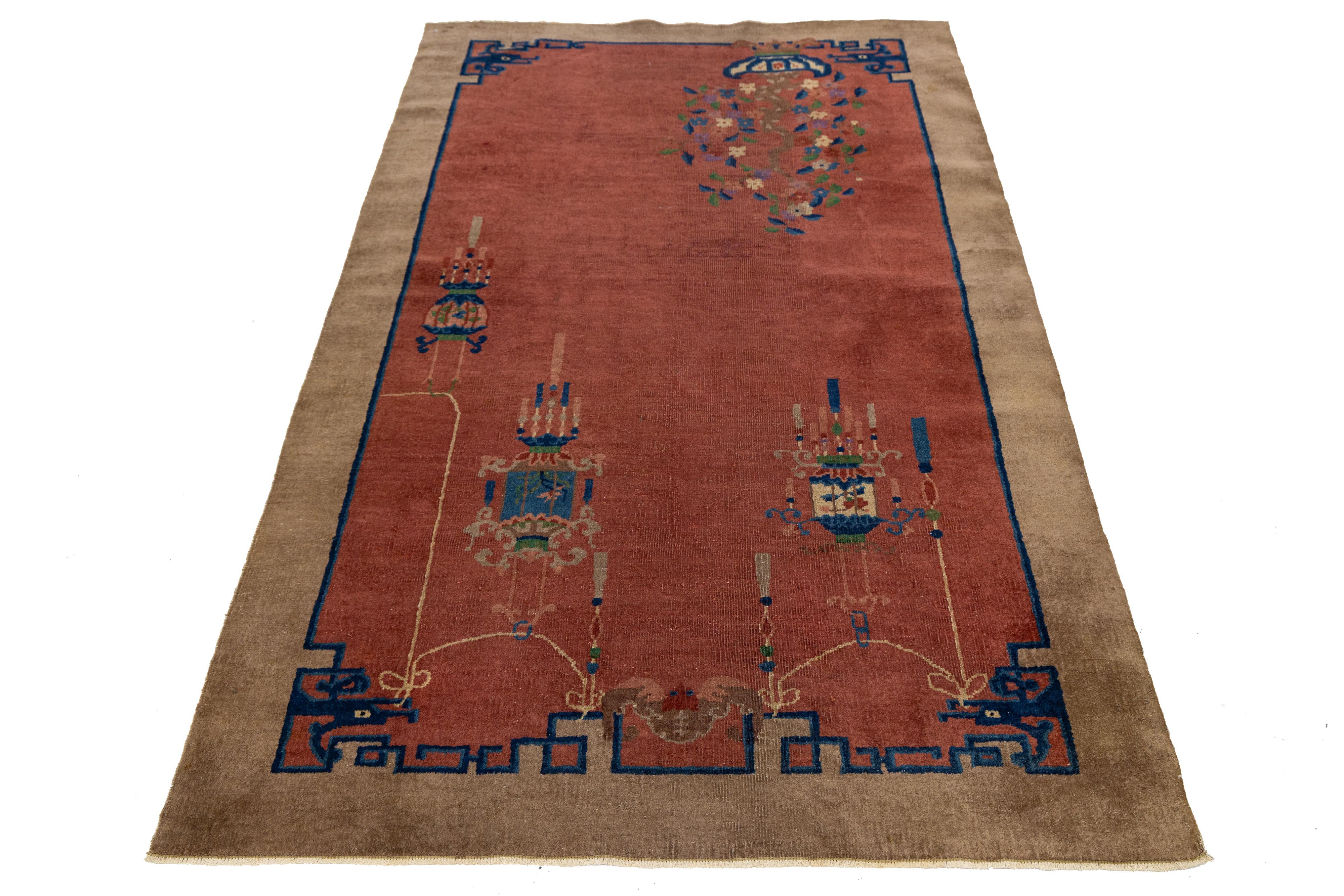 Antiker chinesischer Wollteppich aus den 1920er Jahren mit einem sattroten Feld, umrahmt von einer schokoladenbraunen Bordüre, verziert mit komplizierten Blumenmotiven und symbolischen, sockelartigen Elementen. Handgeknüpft aus weicher Wolle,