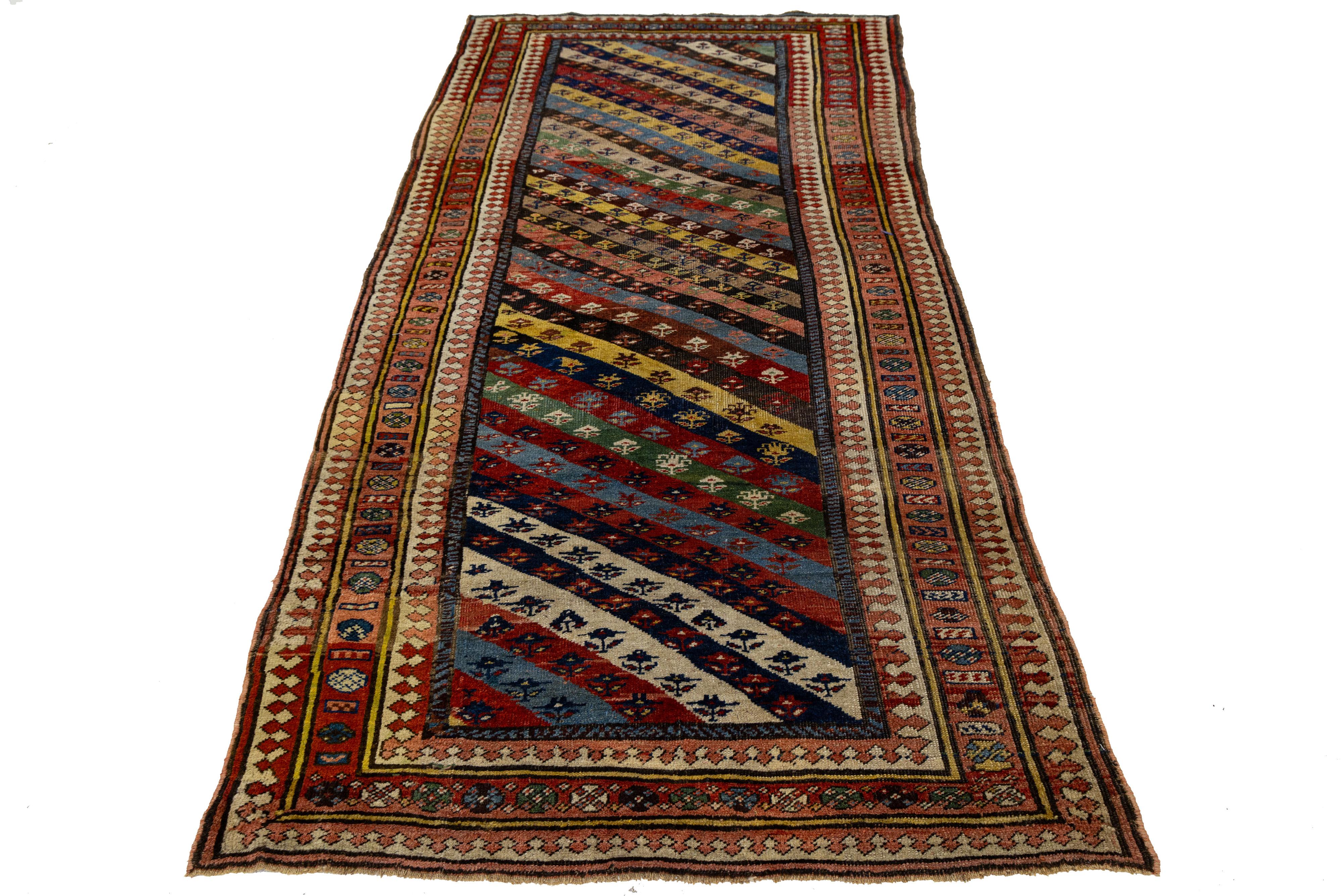 Ce magnifique tapis persan vintage présente un motif en laine noué à la main avec un champ multicolore vibrant. Orné d'un cadre frappant en rouge et beige, il présente un superbe motif géométrique sur toute sa surface qui attire vraiment