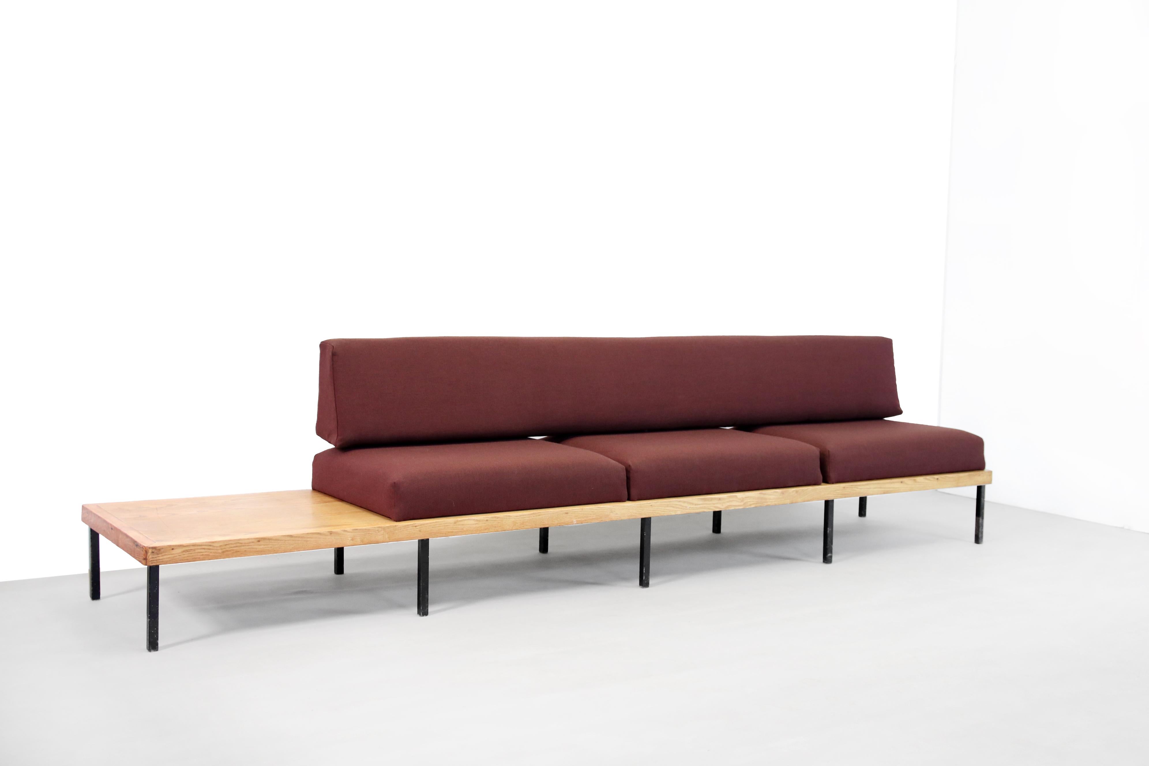 Beautiful Minimalist design bench in oak with a black metal base. The design is very similar to the designs of Kho Liang Ie or Charlotte Perriand from Europe. It is an exceptionally long sofa with integrated table. The cushions and back cushion are