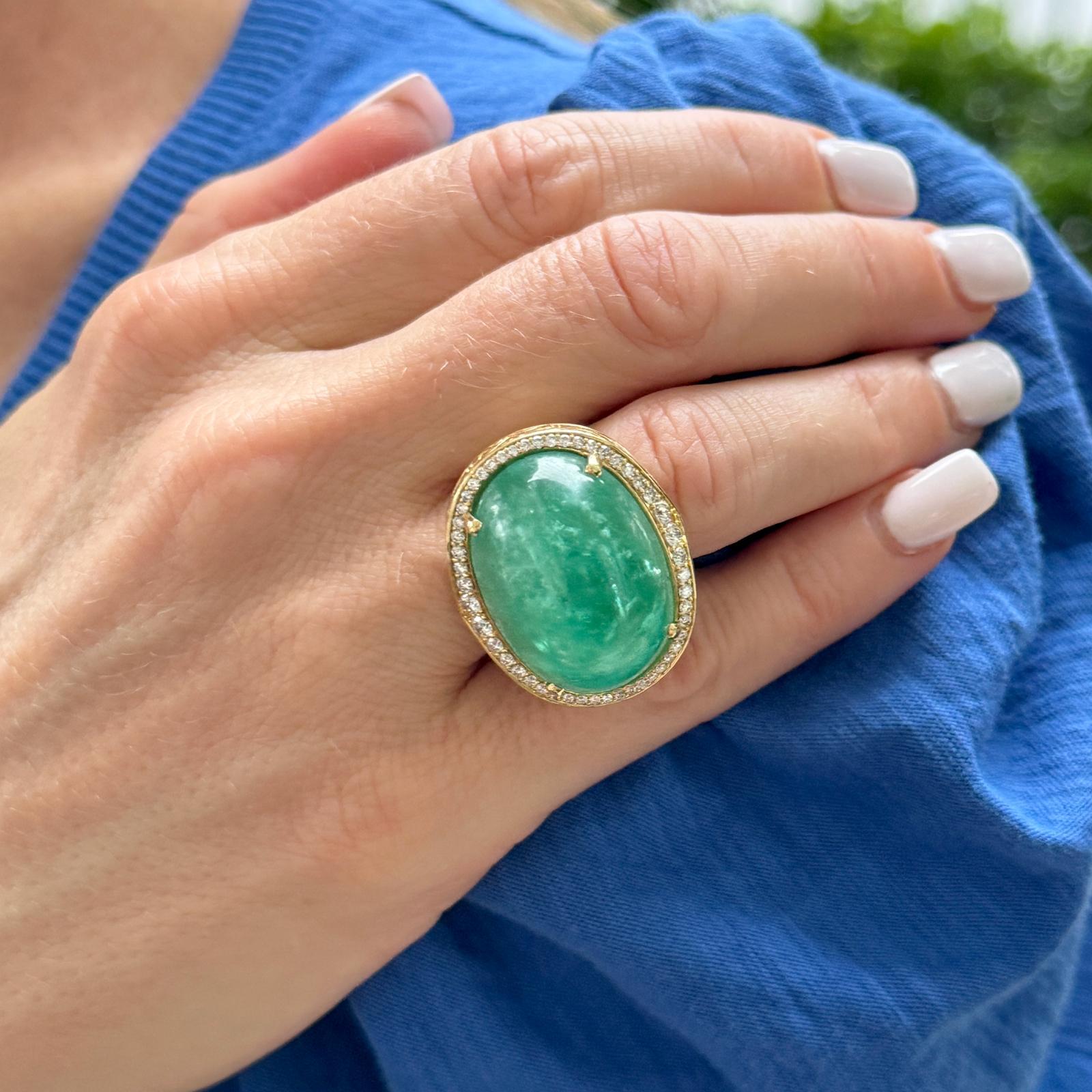 Cette étonnante bague en émeraude cabochon et diamant présente une étonnante émeraude cabochon de 40,54 carats sertie dans une élégante orientation est-ouest. Autour de l'émeraude d'un vert éclatant, 52 diamants ronds brillants, totalisant 0,90