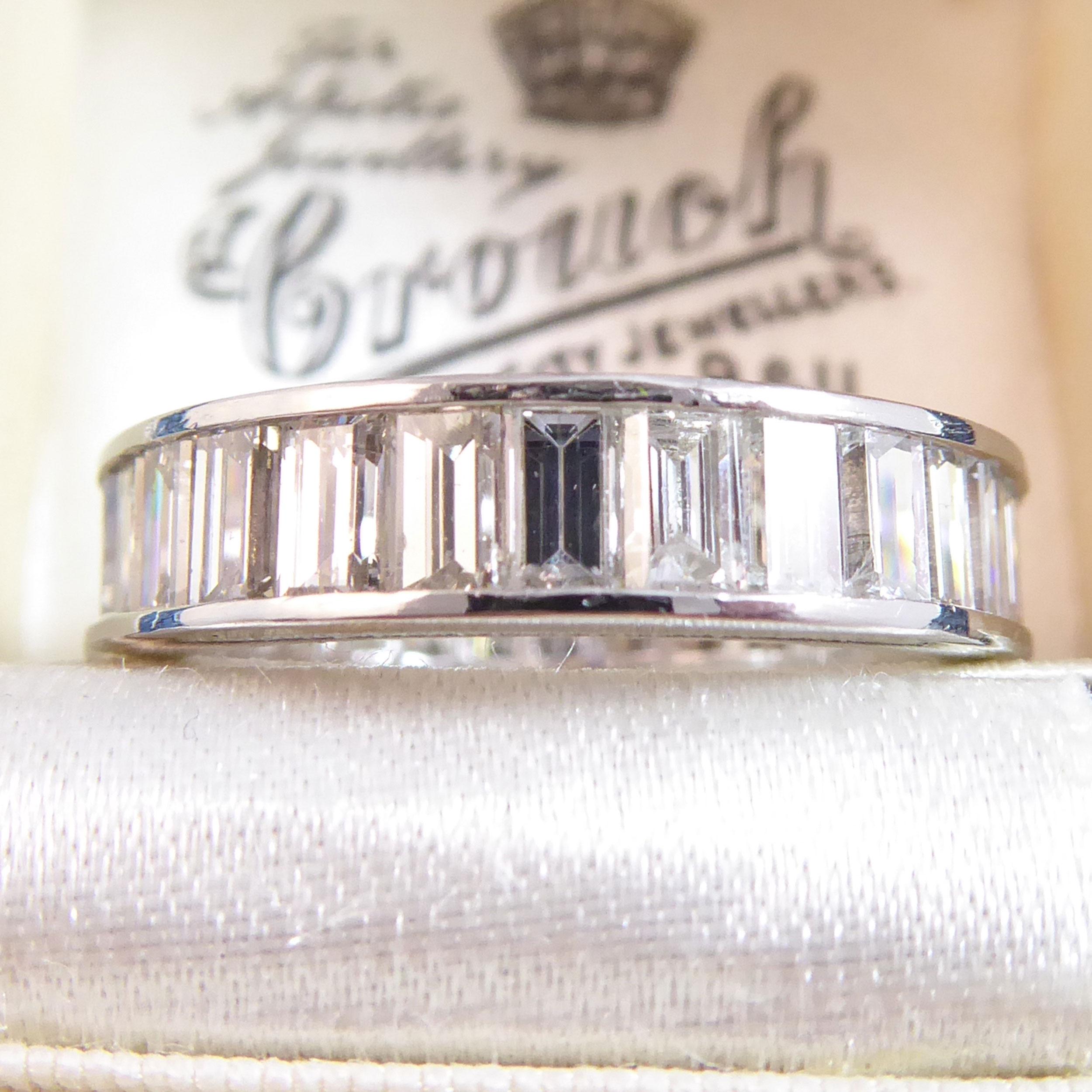 A full circle diamond wedding or eternity ring set with a total of 28 baguette cut diamonds, each measuring approx. 3.5mm x 2.2-2.5mm, channel set into an 18ct white gold band.  The diamonds combine to give a total carat weight of 4.0ct and have