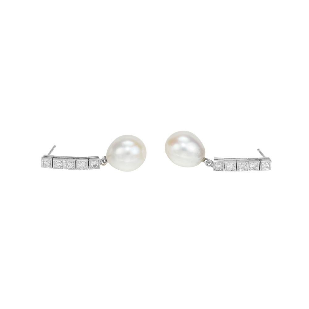Boucles d'oreilles pendantes en perles et diamants. 2 perles blanches de culture d'eau douce mesurant 11,5 mm, chacune attachée à une rangée de 5 diamants de taille brillant en or blanc 14k. Elegant mais simple. 

10 diamants ronds de taille