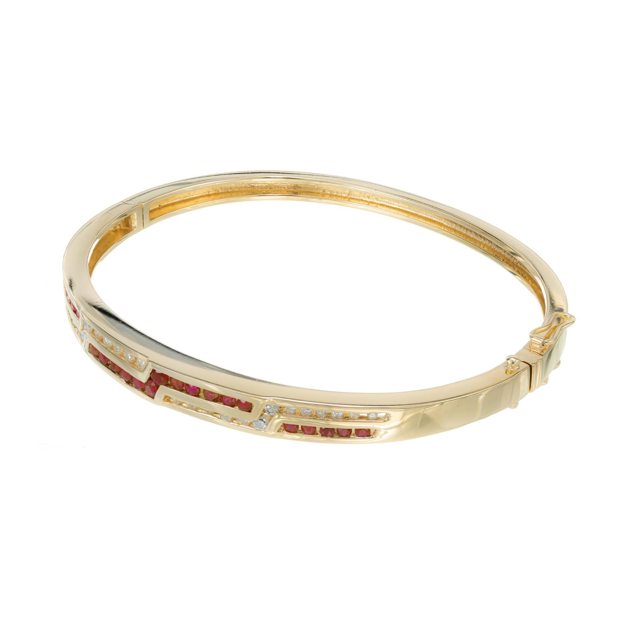 Diamond and ruby 14k yellow gold bangle bracelet. 26 round diamonds with 22 round rubies, channel set. Hinged bangle bracelet with an angular design. 7 inches

26 round diamonds, G-H VS-SI approx. .40cts
22 round red rubies, approx. .40cts
14k
