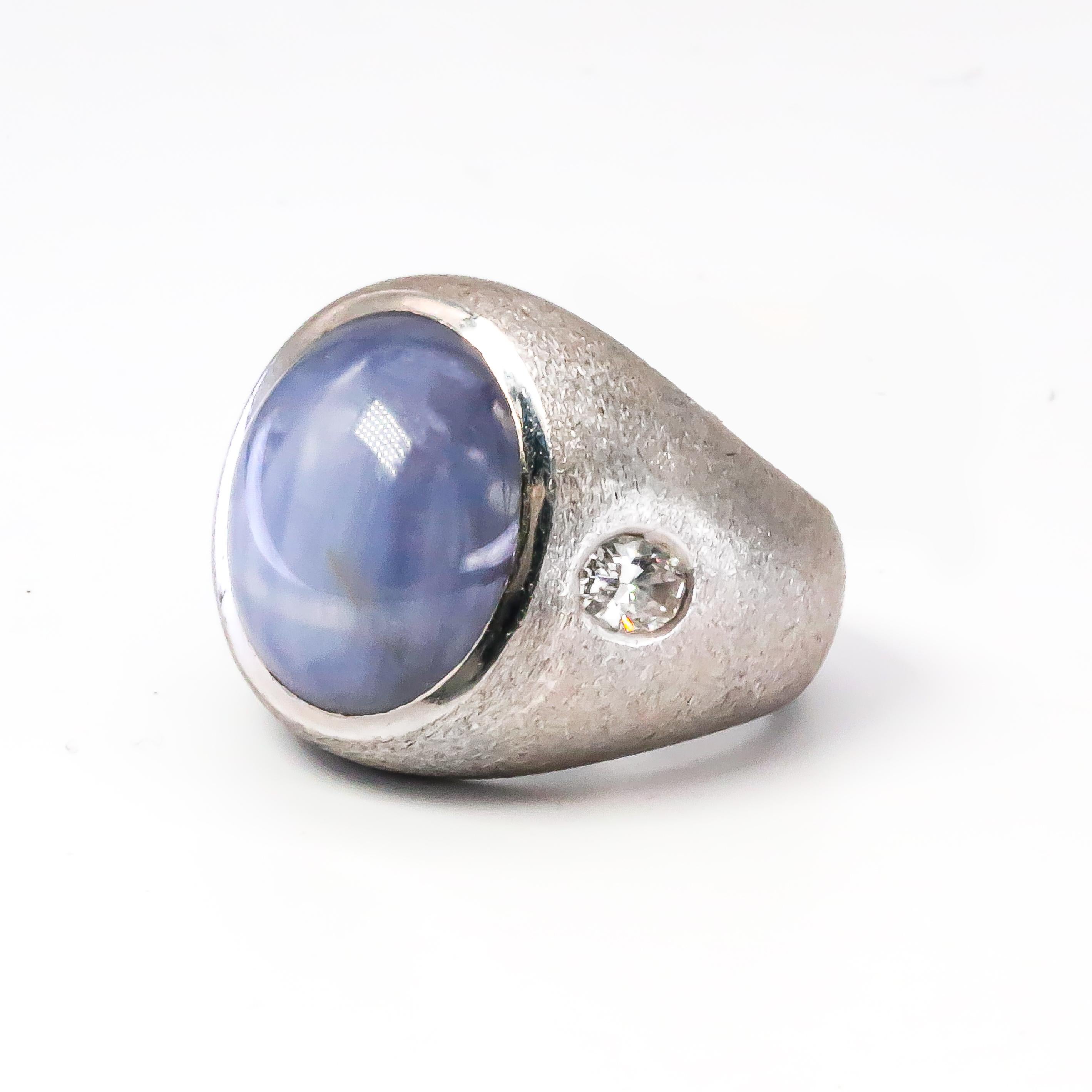 Apart of our unique collection of rare gemstones. This ring proudly presents a double star sapphire, with two diamonds flanking its sides. The formation of the star sapphire's shimmering rays is called asterism, it causes needle like inclusions to