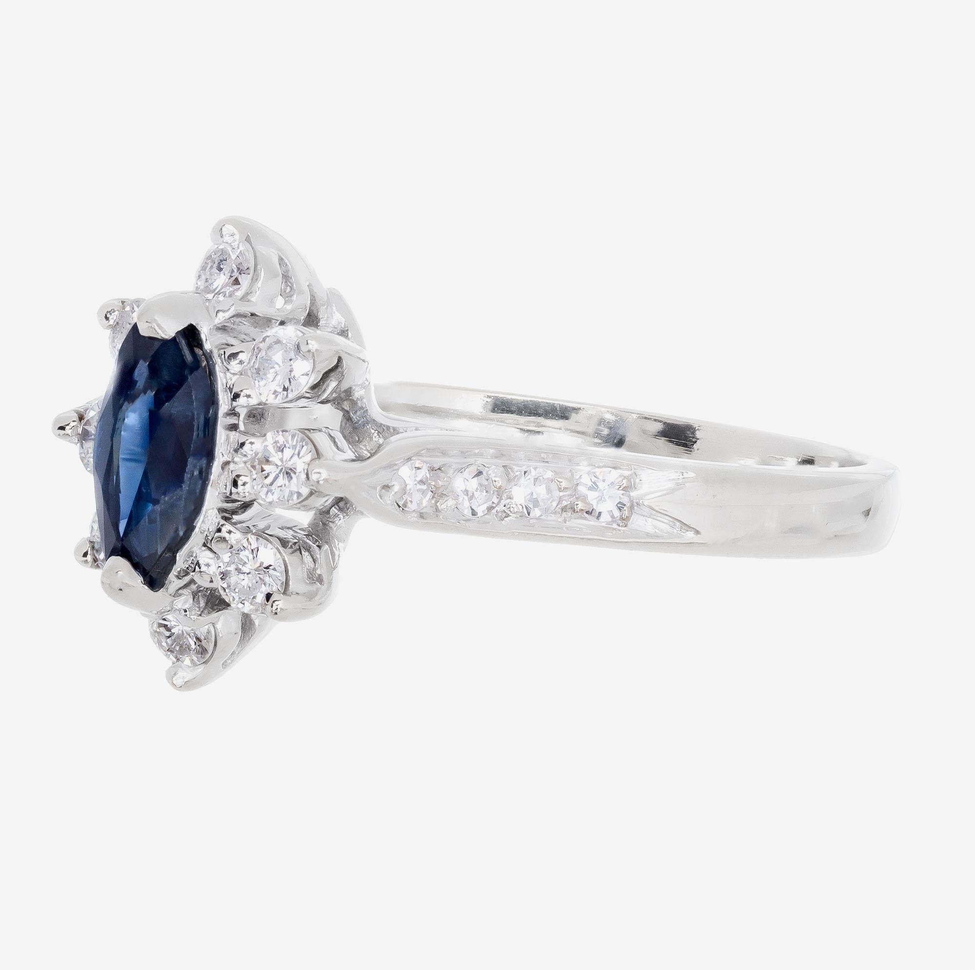 Diamond and sapphire engagement ring. Marquise center sapphire with a halo of round cut diamonds in a 14k white gold setting with round accent diamonds along the shank.    

8 round diamonds approx. total weight .24cts
8 round diamonds approx. total