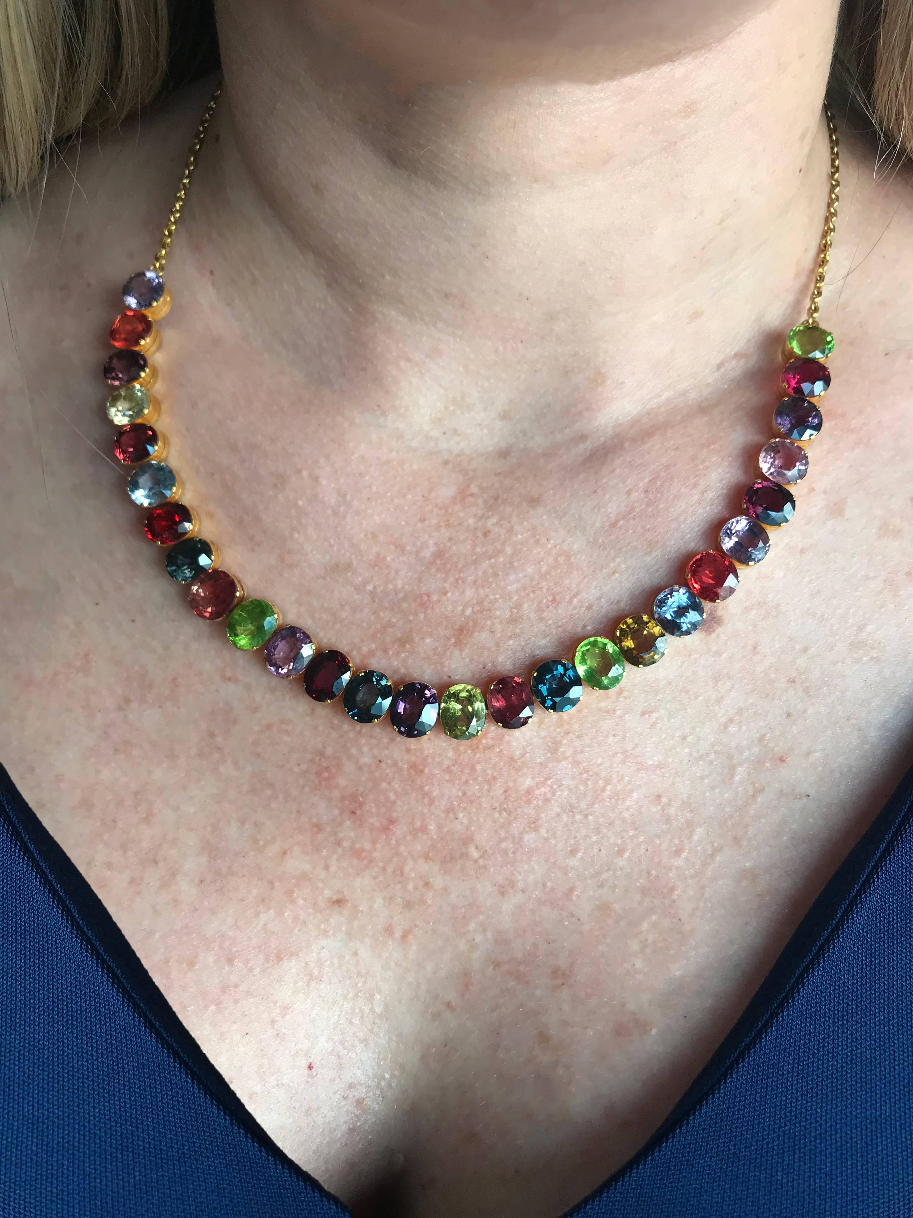 18k yellow gold necklace featuring 27 oval cut Rhodolite, Pyrope and Tsavorite garnets weighing approximately 40cts total. This stunning necklace measures 18 inches in length and measures 9mm at the widest to 1.6mm at the thinnest Garnets come in a