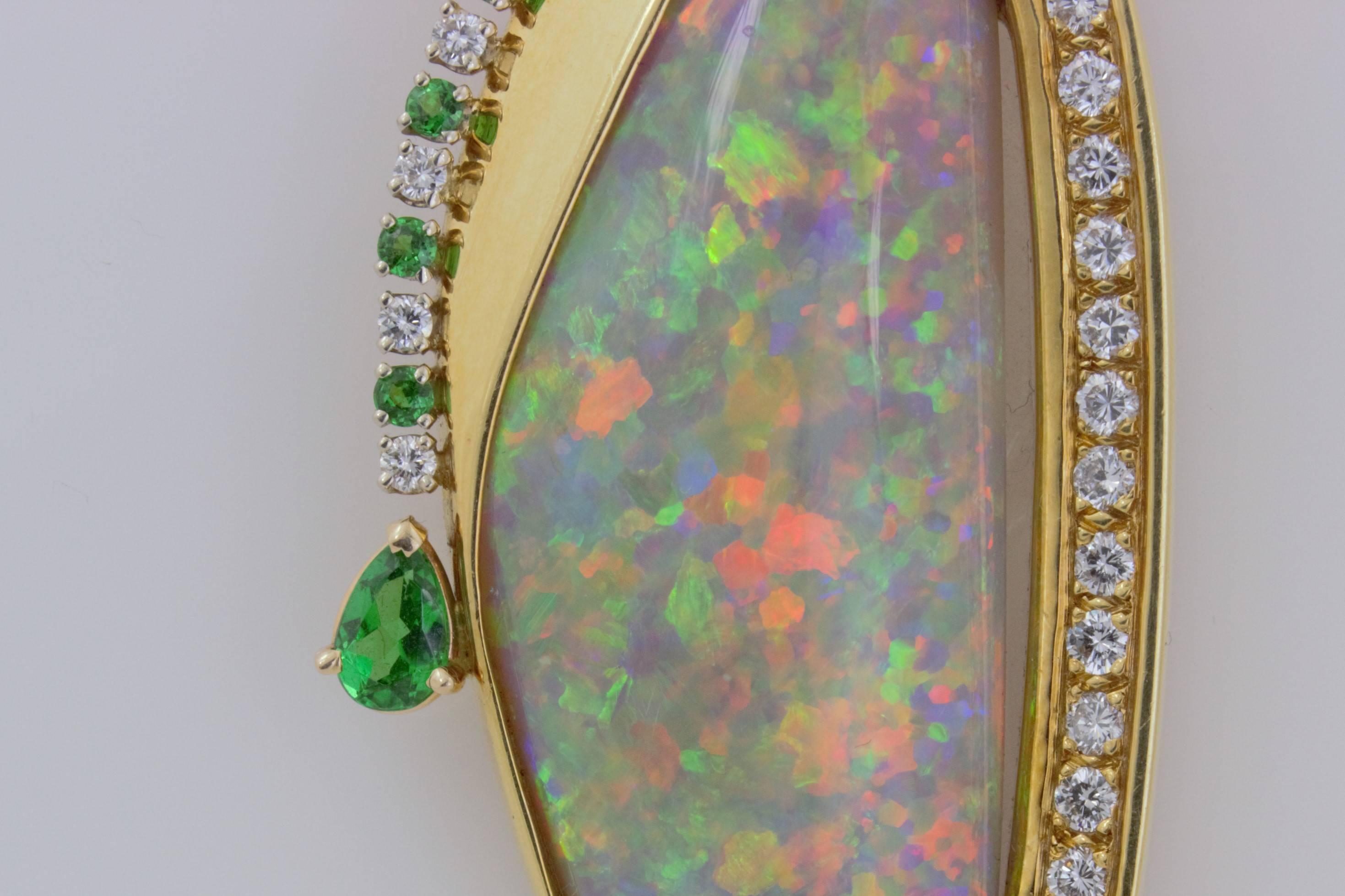 This is a one of a kind 14 karat yellow gold 40 carat, multi color, harlequin pattern, free form custom opal pendant with .71 carats of diamonds, a .48 carat pear shaped Tsavorite garnet,  two pink sapphires totalling .88 carats, and 1/3 carat of