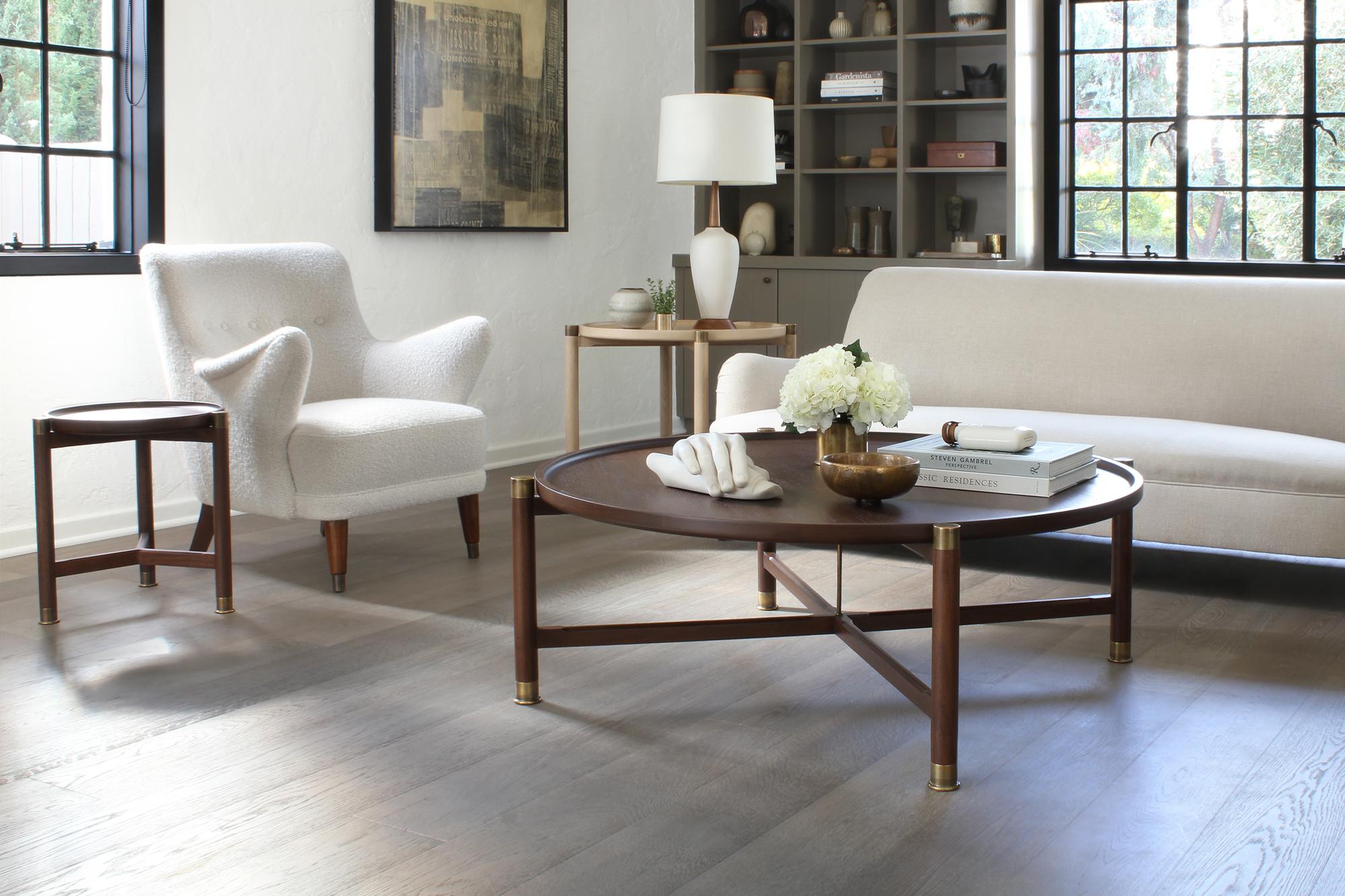 The Otto coffee table is a handsome, generously proportioned table with a timeless form.
Available in walnut or oak, it features a round coupe top, substantial antique brass fittings, and sleek chamfered stretchers. The epitome of understated
