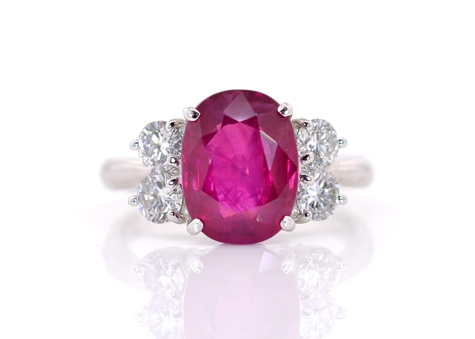 A beautiful faceted step-cut 4.00 carat oval Burma Ruby of a soft yet deep red, certified by Swiss lab, GRS. The natural Ruby, pleasing to the eye, is flanked by four Round Brilliant cut Diamonds, all weighing 0.68 carat of G/H color - VS clarity