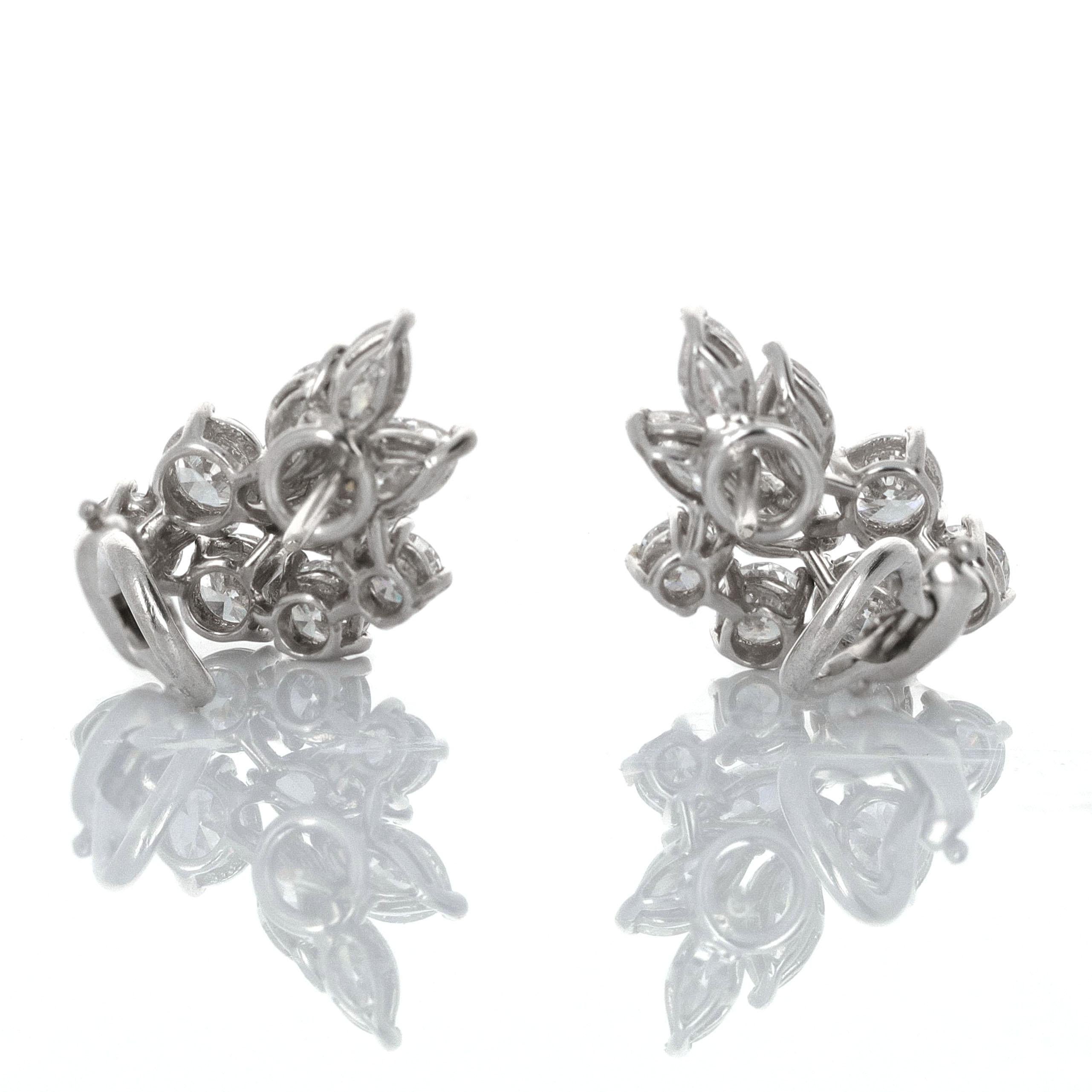 1 8 karat white gold diamond cluster earrings. There is an estimated 4.00 carats total weight. The earrings are composed of round and marquise shaped diamonds. The Diamonds are white in color and eye clean
