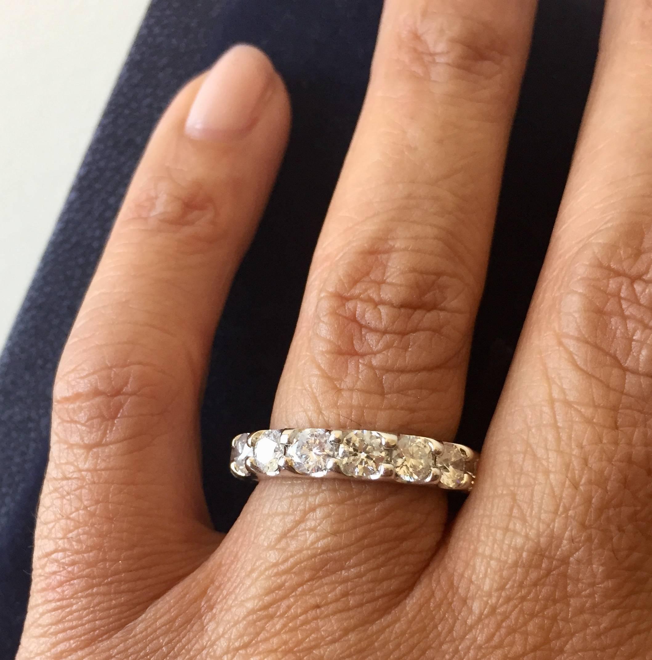 This low setting, shared prong eternity band, is one of the most desirable rings on the market today. The U- Prong of the ring sets the stones low which makes the ring very comfortable, and gives the illusion of a bigger stone. The color and clarity