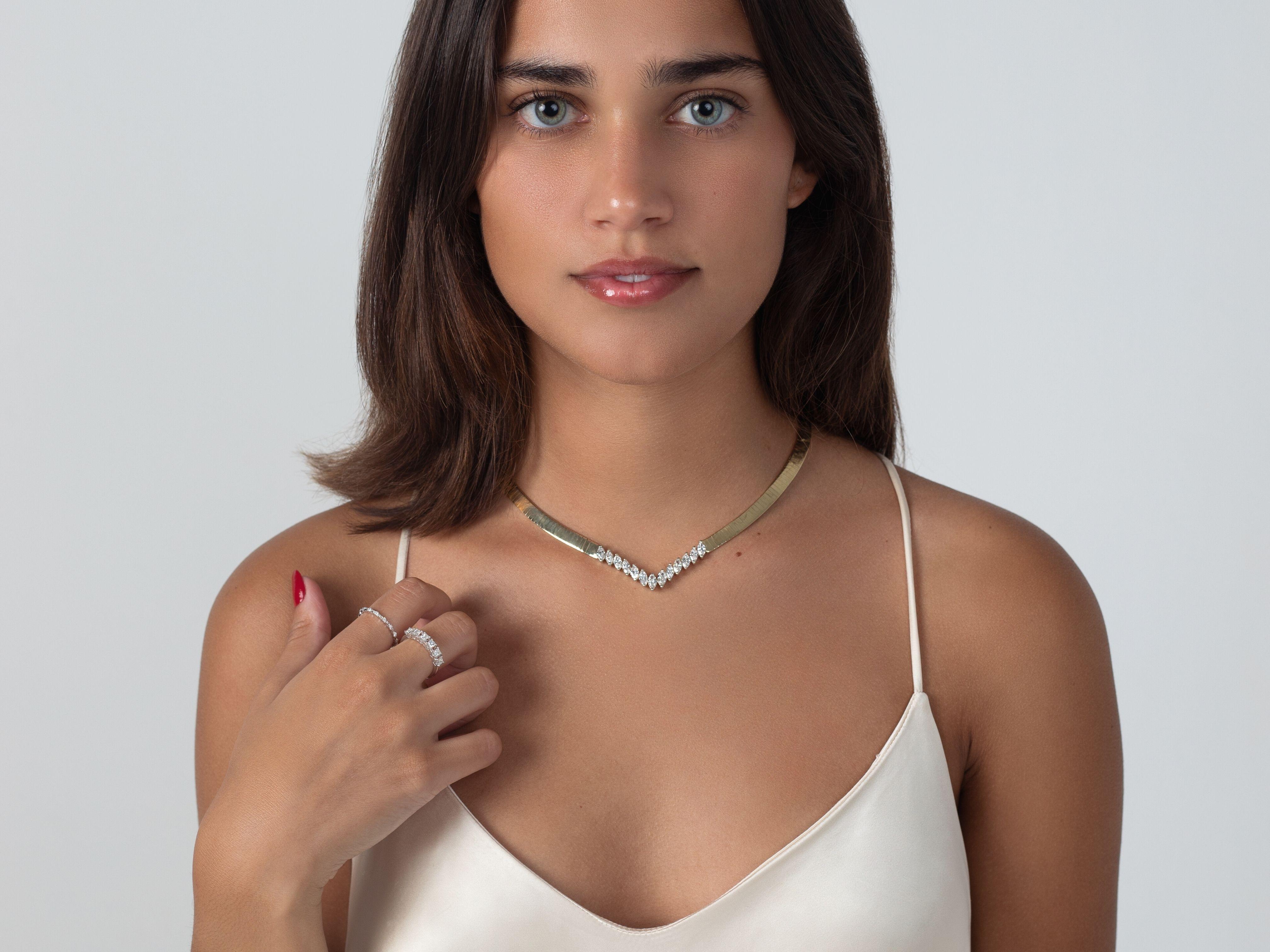 13 Marquis-Cut white diamonds totaling approximately 4.00 Carats and set in 39 grams of 14K solid yellow gold The diamonds are prong set and mounted in a gorgeous herringbone necklace that sits gracefully on the neckline. The diamonds are all