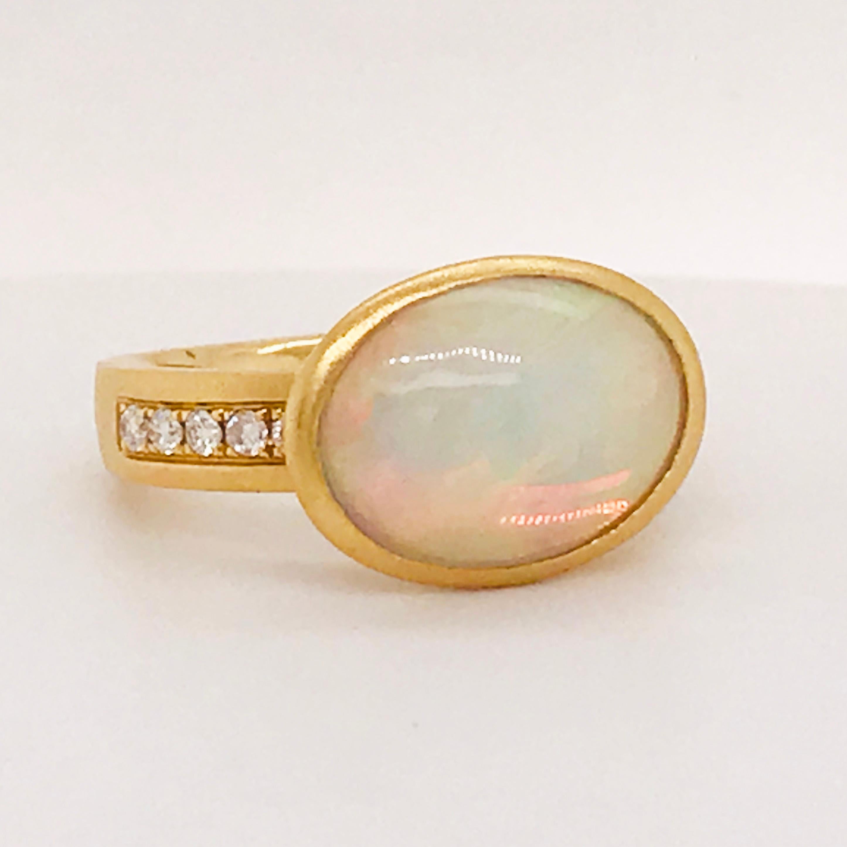 This one of a kind opal and diamond ring has a 4.12 carat genuine opal set East to West in a hand made bezel setting. The bezel setting has a smooth, brushed, or satin, finish. The center opal has a ton of fire! It's so beautiful and reflects a