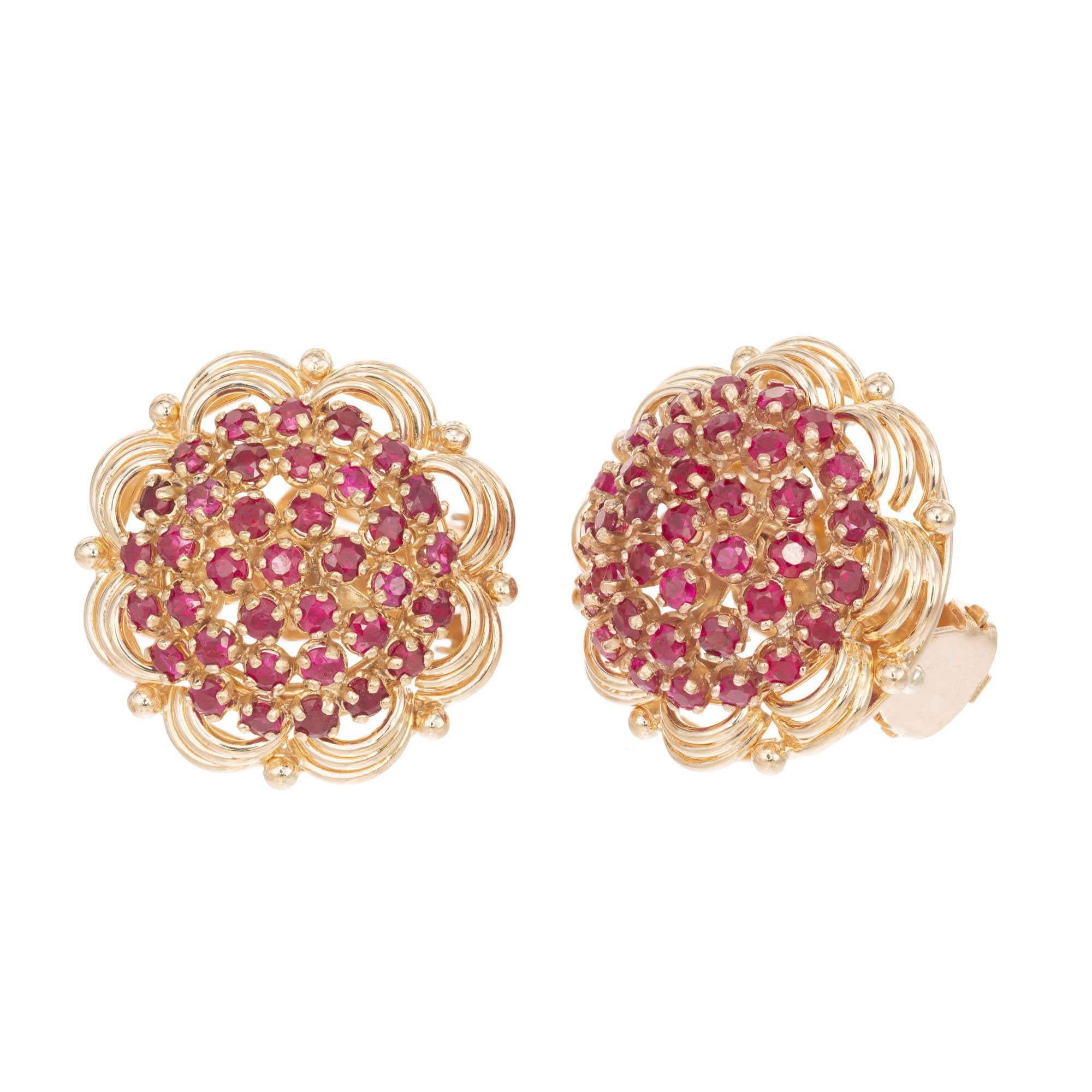 Vintage 1950s ruby clip post cluster earrings with 18k yellow gold flower design halo.

70 round red rubies, Approximate 4.00 carats 
18k Yellow Gold 
Stamped: 750 18k
15.8 Grams 
Top to Bottom: 22.05mm or .86 Inches 
Width: 22.05mm or .86 inches 
