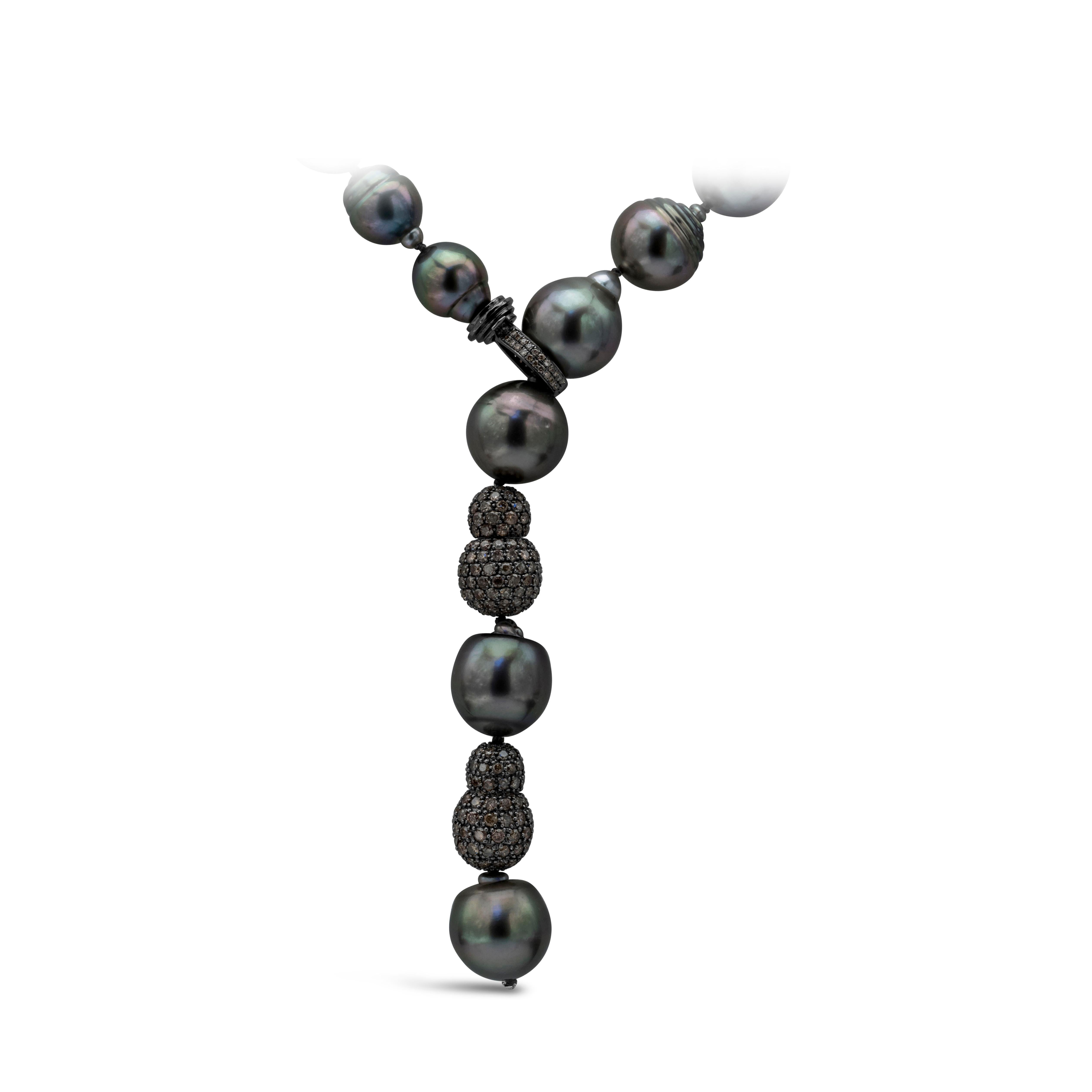 Precioso collar de perlas, con perlas negras barrocas de Tahití de 10-13,7 mm y cierre de diamantes negros. Acentuado por dos bolas negras con diamantes incrustados. Los diamantes negros pesan 4.00 quilates en total. Finamente fabricado con rodio