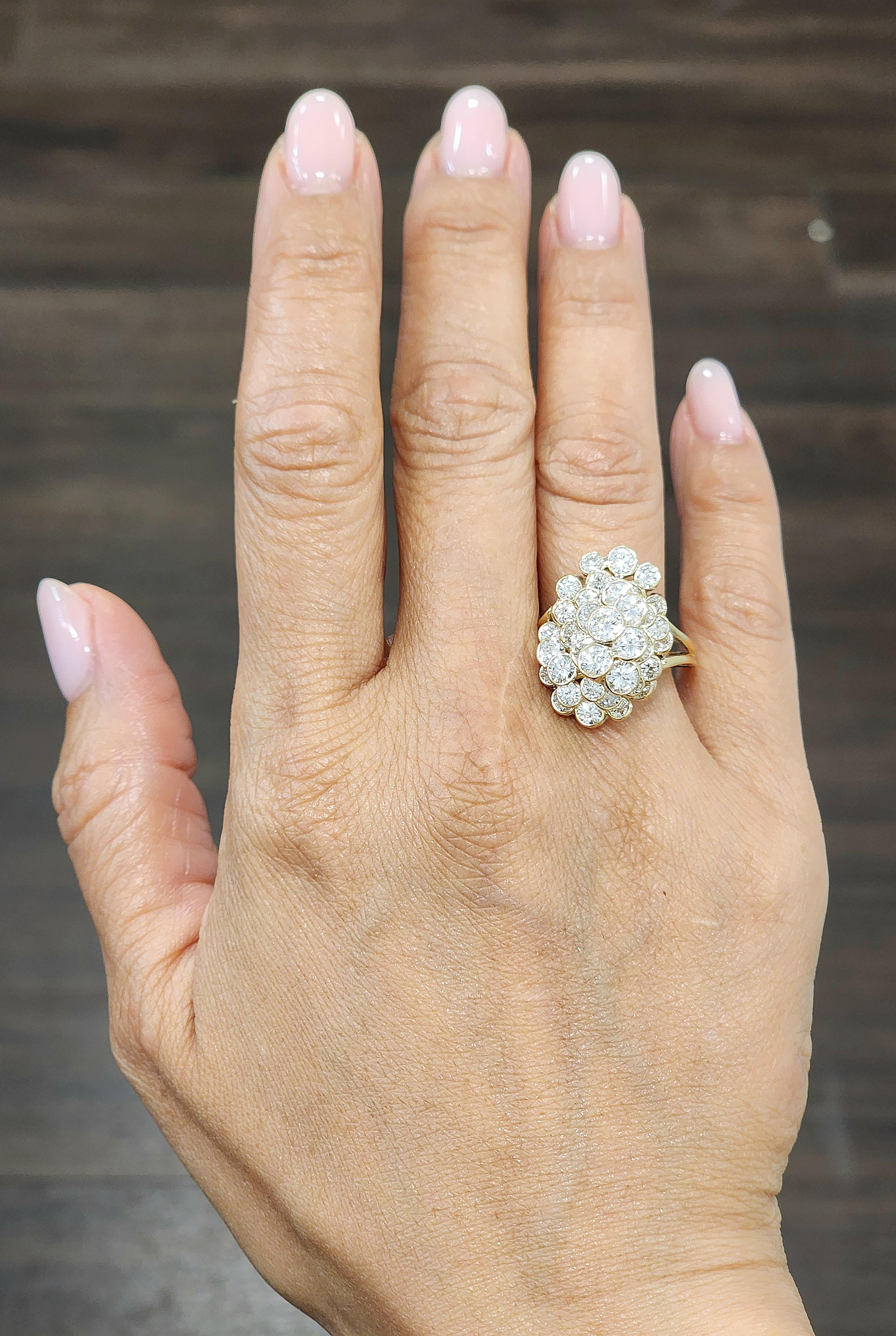 Cette bague de cocktail présente un design en grappe complexe avec de multiples pierres rondes, créant un effet éblouissant. Chaque pierre est sertie dans de l'or jaune 14k, ce qui rehausse la brillance de l'ensemble. Les pierres principales sont