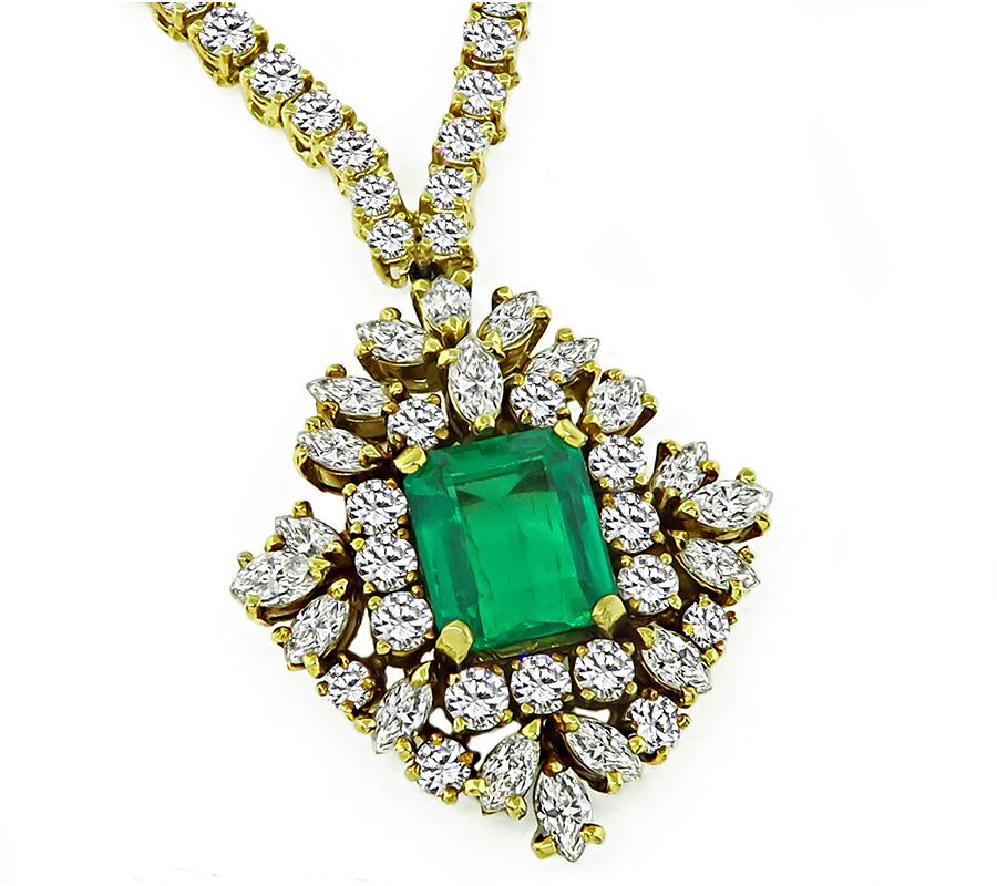 This is a charming 18k yellow gold pendant necklace. The necklace is centered with a lovely emerald cut Colombian emerald that weighs approximately 4.00ct. The emerald is accentuated by sparkling marquise and round cut diamonds that weigh