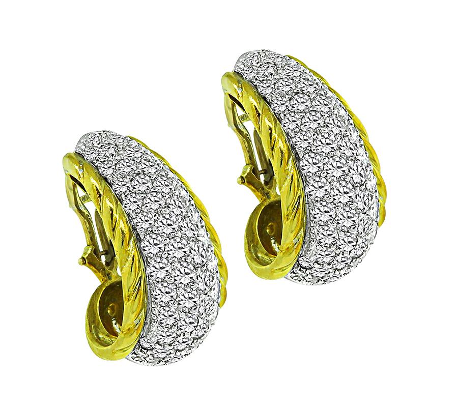 This is a charming pair of 14k yellow and white gold earrings. The earrings feature sparkling round cut diamonds that weigh approximately 4.00ct. The color of these diamonds is F-G with VS clarity. The earrings measure 26mm by 15mm and weigh 15