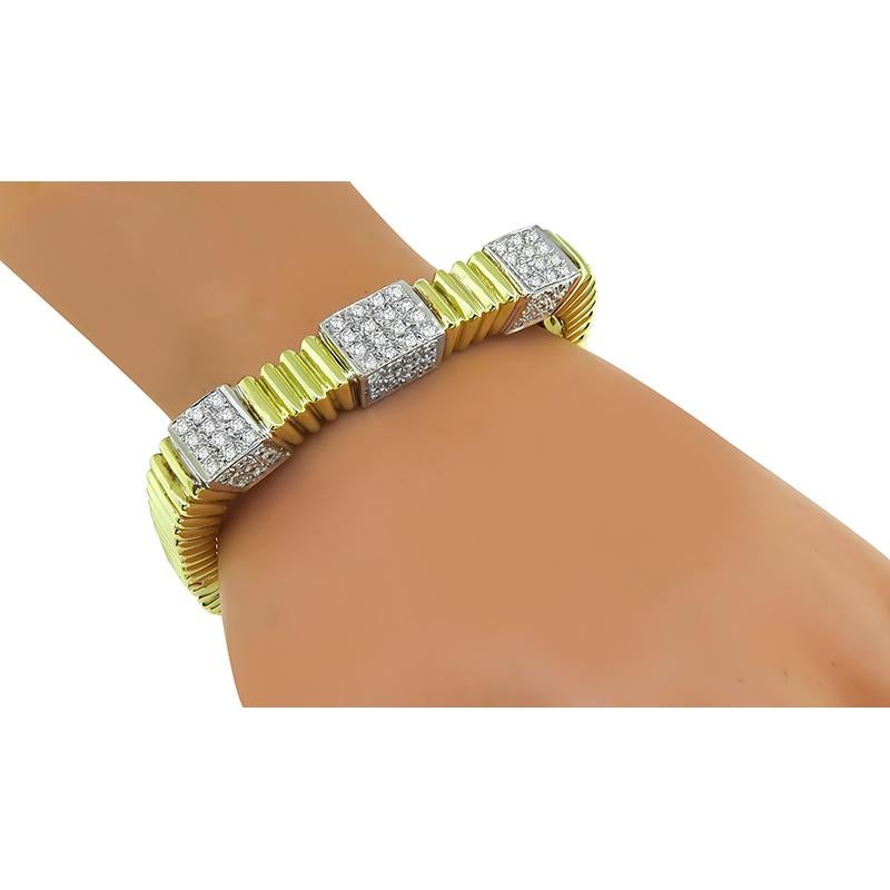 This is a gorgeous 18k yellow and white gold bangle. The bangle is set with sparkling round cut diamonds that weigh approximately 4.00ct. The color of these diamonds is H-I with VS clarity. The bangle measures 10mm in width at the widest base and