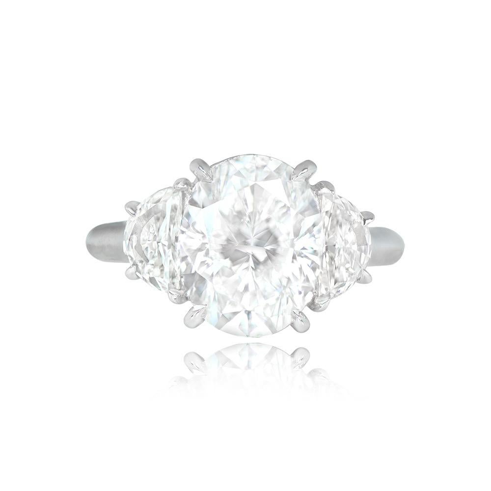 This engagement ring highlights a 4.00-carat oval-cut diamond with G color and VS2 clarity, securely set in prongs. It's elegantly complemented by two half-moon-shaped diamonds, totaling 0.81 carats in weight, featuring G-H color and VS1 clarity.