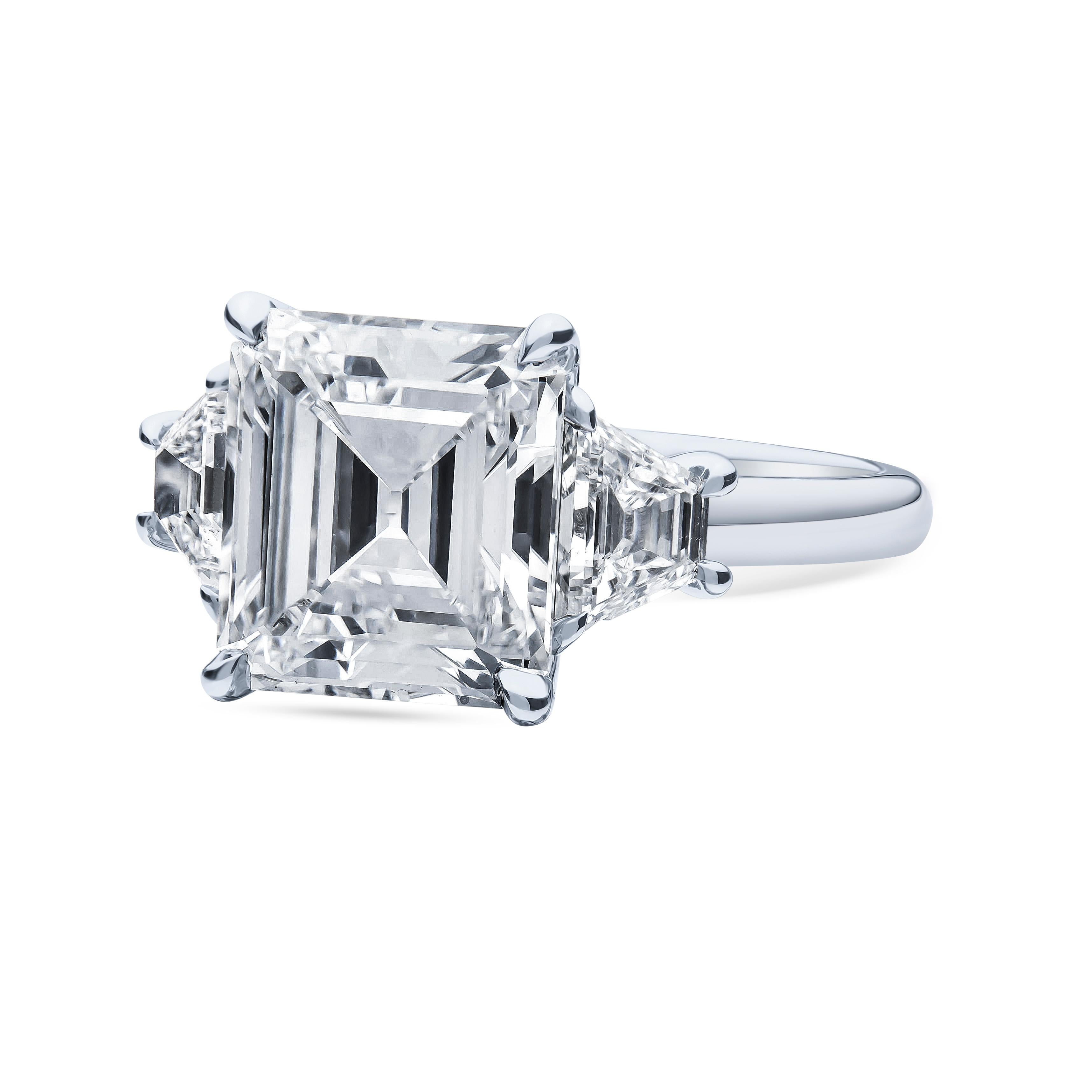 Captivating three-stone diamond showcasing a rare vintage 4.00ct square emerald cut natural diamond, D color, VVS1 clarity, designed in platinum. The side diamonds are perfectly matched trapezoid cuts weighing 0.90 carats total with F-G color,