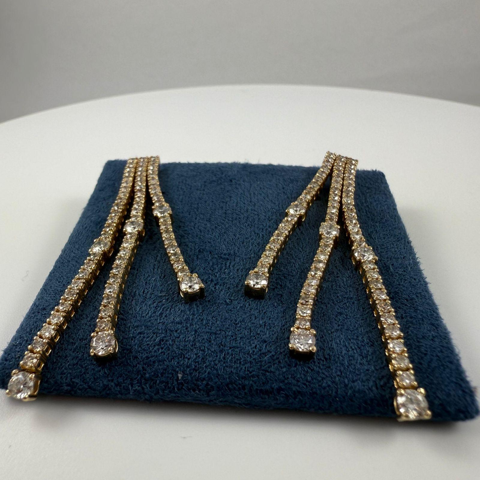Eleganti e radiosi, questi orecchini a tre file di diamanti sono progettati per abbagliare con movimento e brillantezza. Con un totale di 140 diamanti rotondi con taglio a brillante, gli orecchini presentano un design fluido in cui ogni fila è