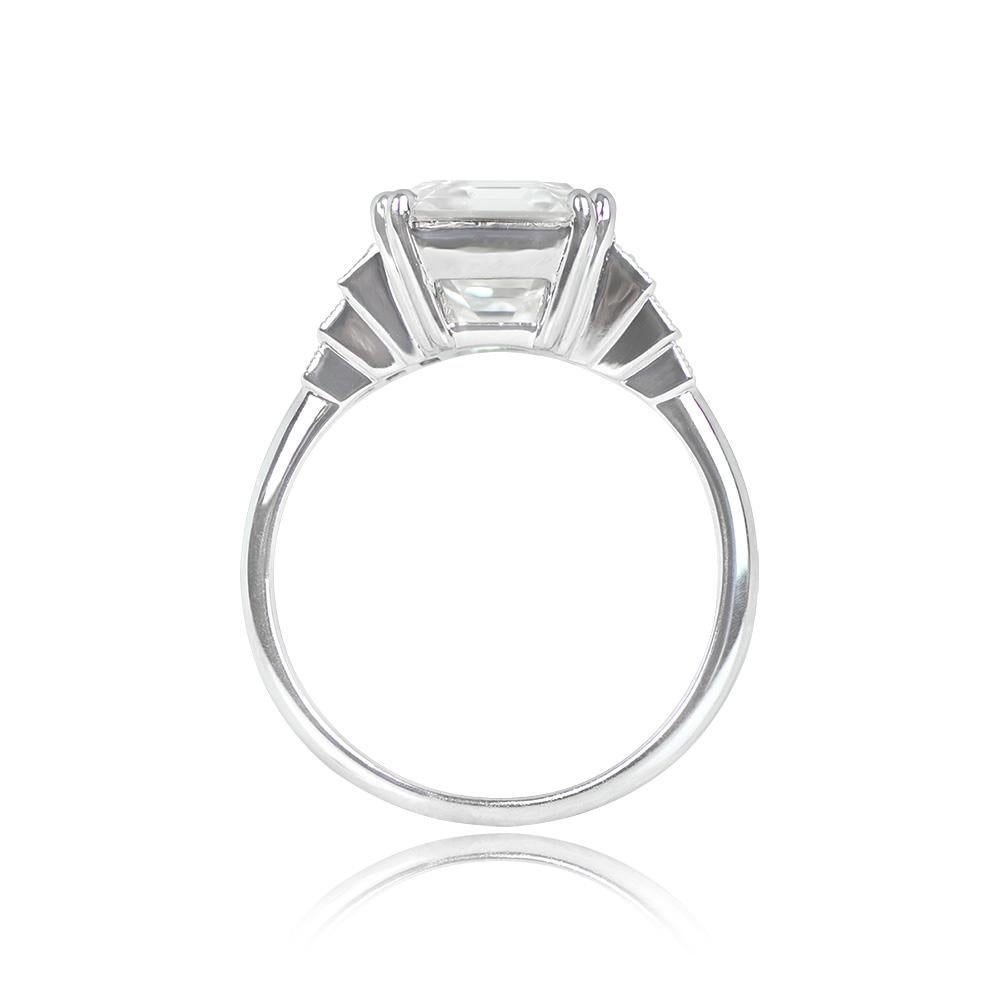 Introducing a breathtaking engagement ring that places a prong-set Asscher cut diamond at its heart, weighing an impressive 4.01 carats, exhibiting a delightful J color and VS1 clarity. Adding to its allure, three baguette-cut diamonds gracefully
