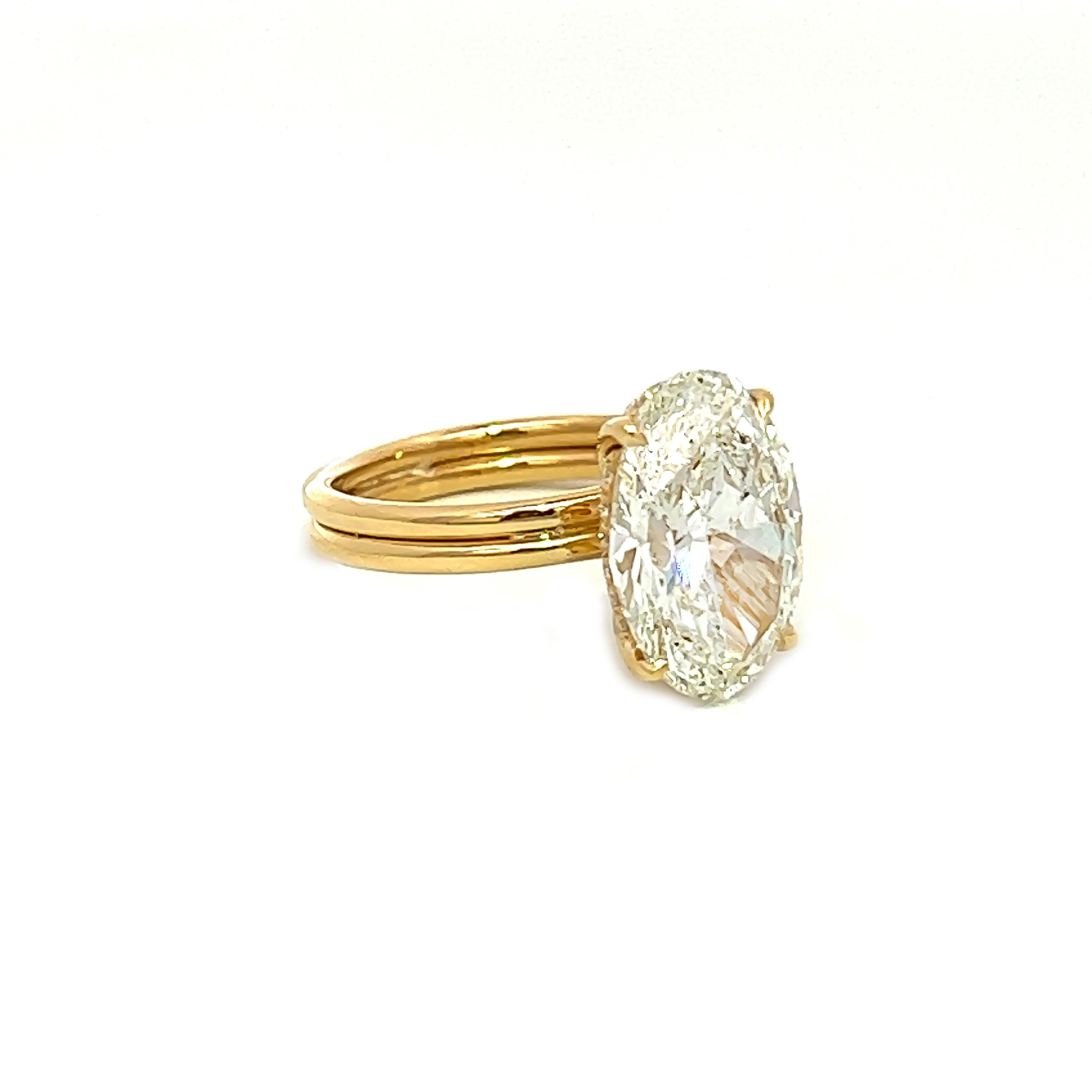 This stunning piece showcases a 4.01-carat oval-shaped natural diamond, GIA CERTIFIED, boasting an H color and SI1 clarity. Encircled by a halo of round diamonds, the piece is crafted from 18k yellow gold. It is an exceptional and eternal present