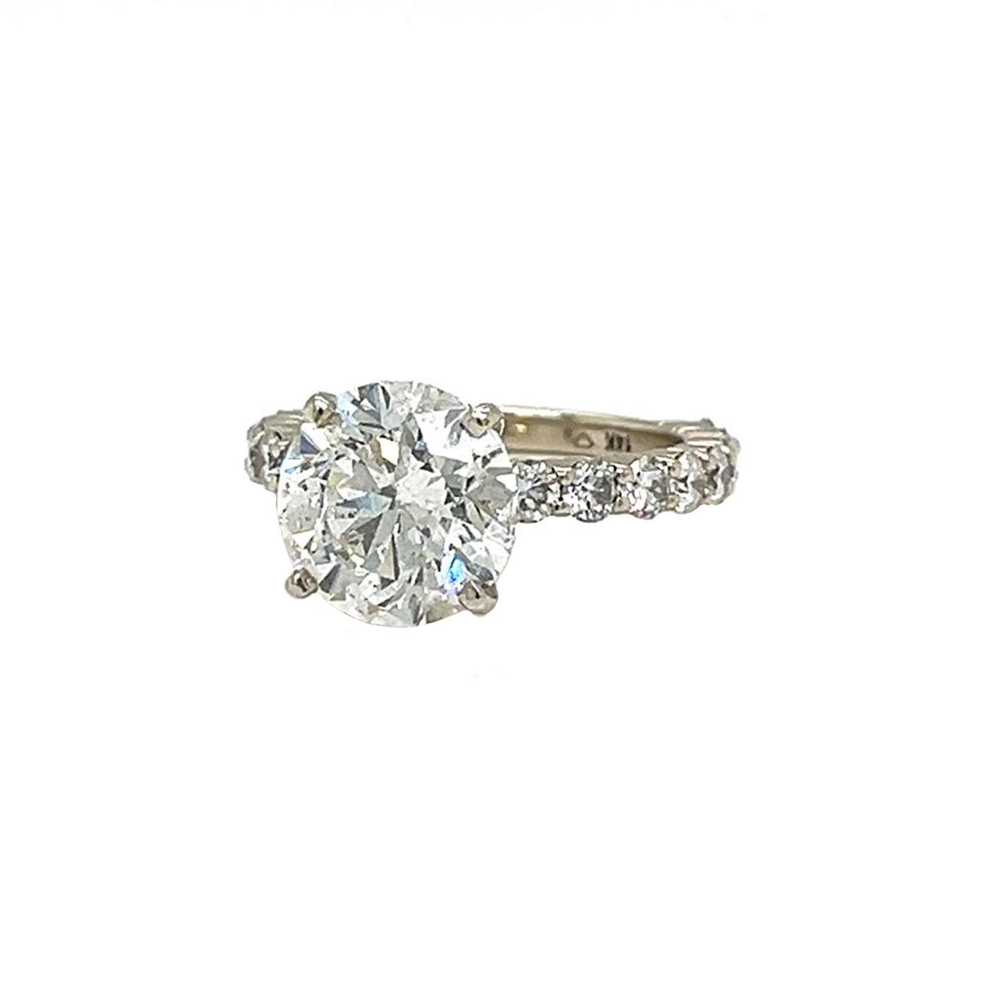 This lovely engagement ring features a sparkling 4.01-carat round diamond with additional diamonds, with more diamonds lining the 14K white gold band. The ring has a total of 8 side diamonds. Like a star shining bright, this ring shines in every